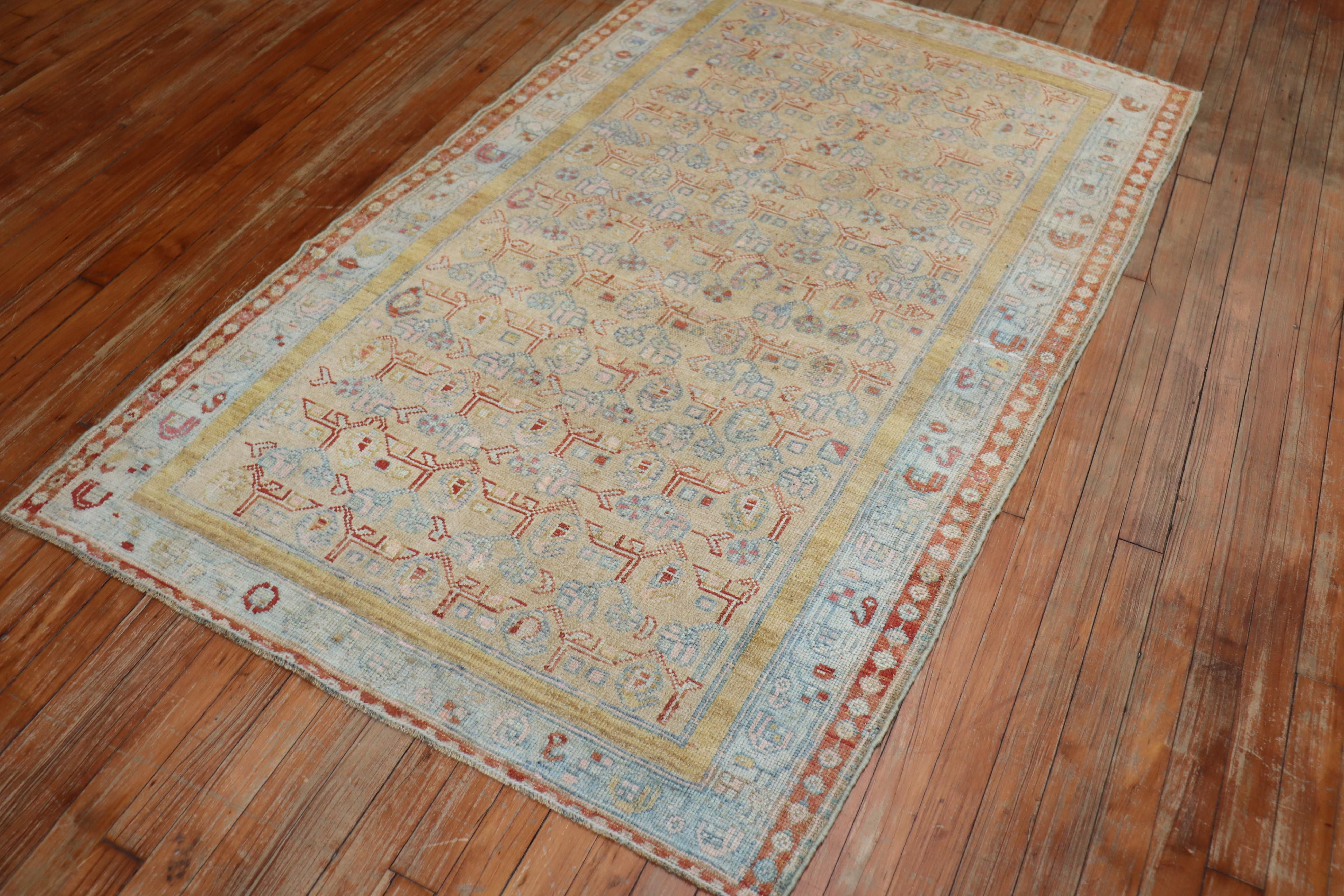 An early 20th century Persian Kurdish rug in muted tones. The field is a pale brown, light blue border, accents in pink, terracotta, and rust.

Measures: 3'8