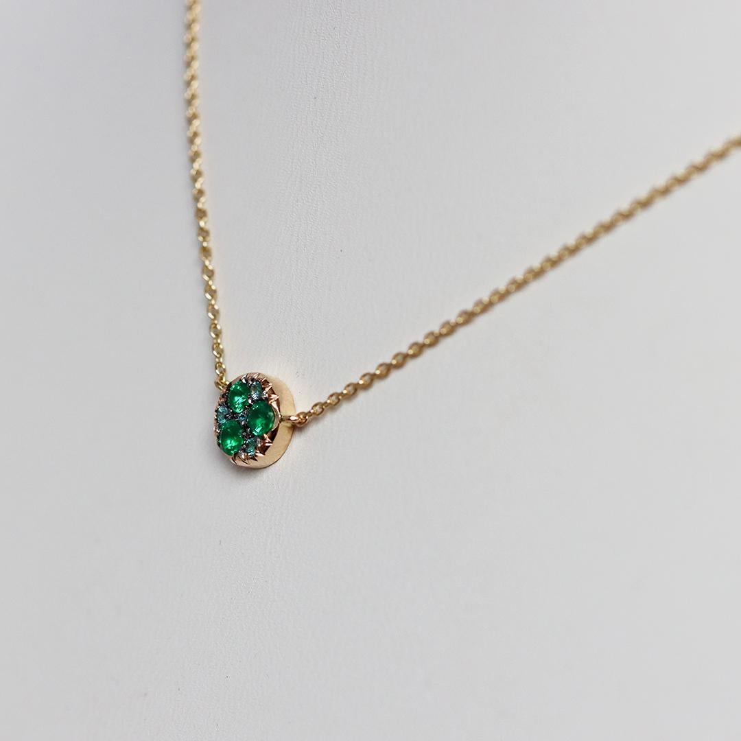 Questo straordinario ciondolo di alta gioielleria con collana, opera dell'artista Joke Quick, presenta un mosaico ipnotico di smeraldi colombiani Muzo, tormaline Paraïba e piccoli diamanti bianchi, meticolosamente incastonati in un design a