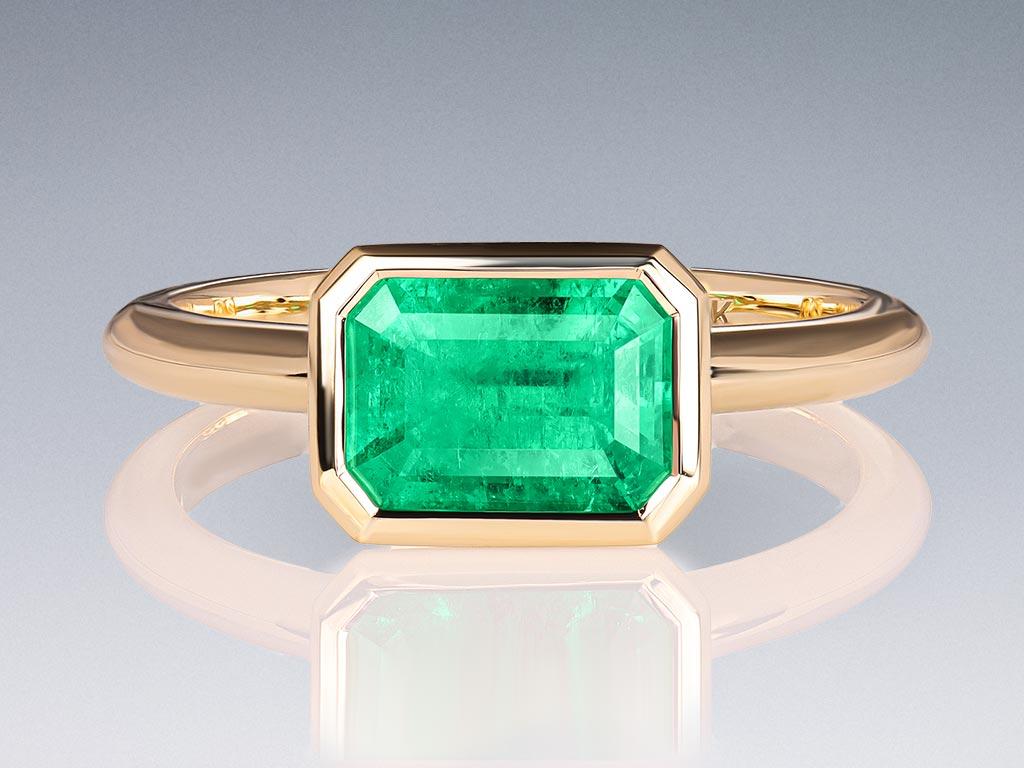 The Muzo Green Colombian Emerald 1.57 ct, gracefully nestled in the sophisticated yellow gold setting, creates a stunning visual impact, capturing attention and radiating in any light. The refined shape, expert craftsmanship, and the sparkle of the