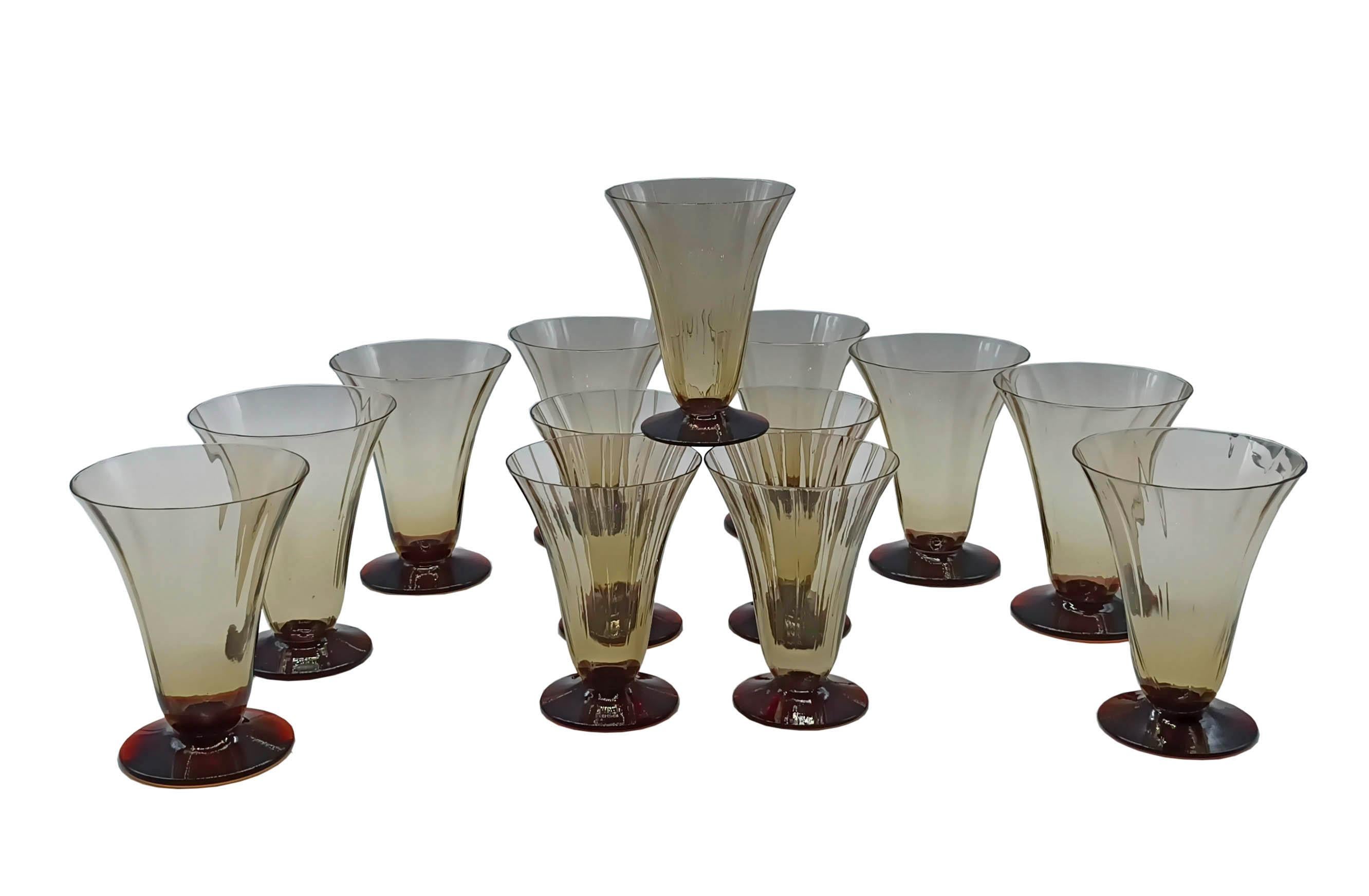 Set of 12 goblets ( 6 for water and 6 for wine ) Art Deco' ribbed thin-blown Murano glass made in Italy in the 1930s.  The goblets are trumpet-shaped with a light amber color  deep red/orange disc foot.