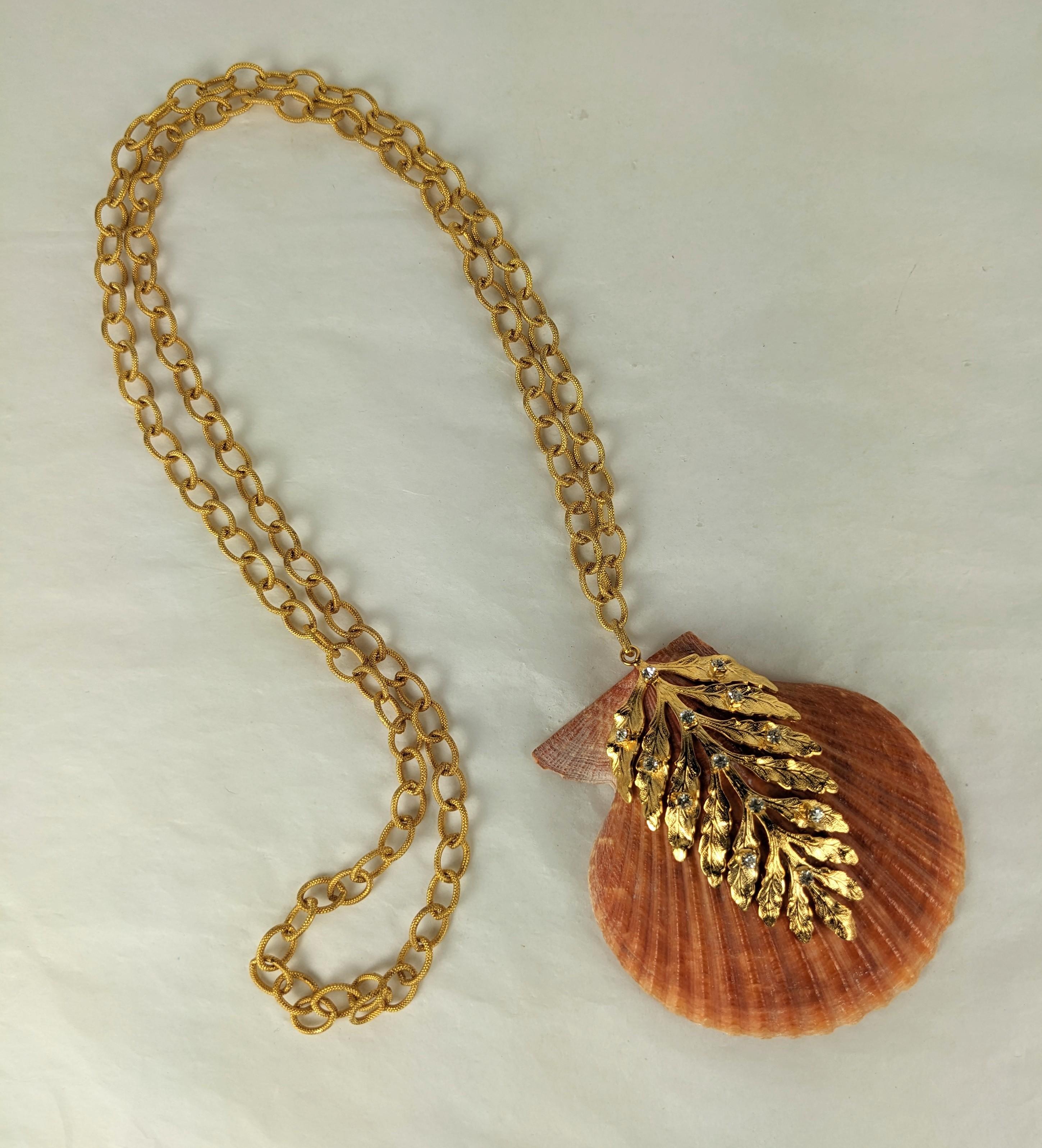 Coral Orange Lion Paw Scallop Shell pendant necklace from MWLC. The natural shell decorated with a gilt plate bronze fern frond, decorated with prong set crystal rhinestones, made in the Parisian studios of MWLC. Textured matte gold chain slips over