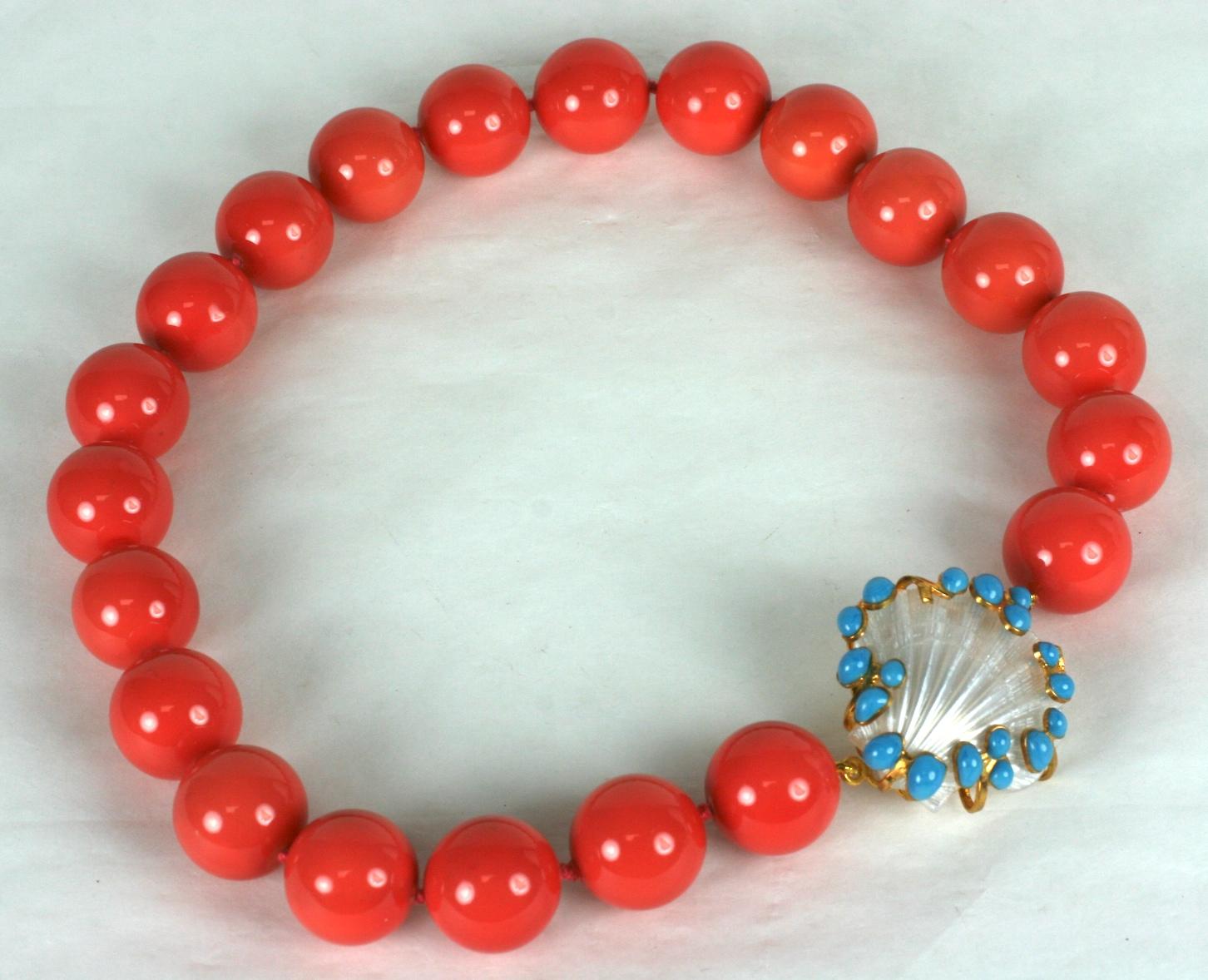 Coral lacquered hand knotted Mother of pearl beads with custom shell clasp with poured glass turquoise cabochons. Clasp is vintage resin shell decorated with colorful cabs. Made in the Parisian studios of Mark Walsh Leslie Chin.
Coral beads 17.5