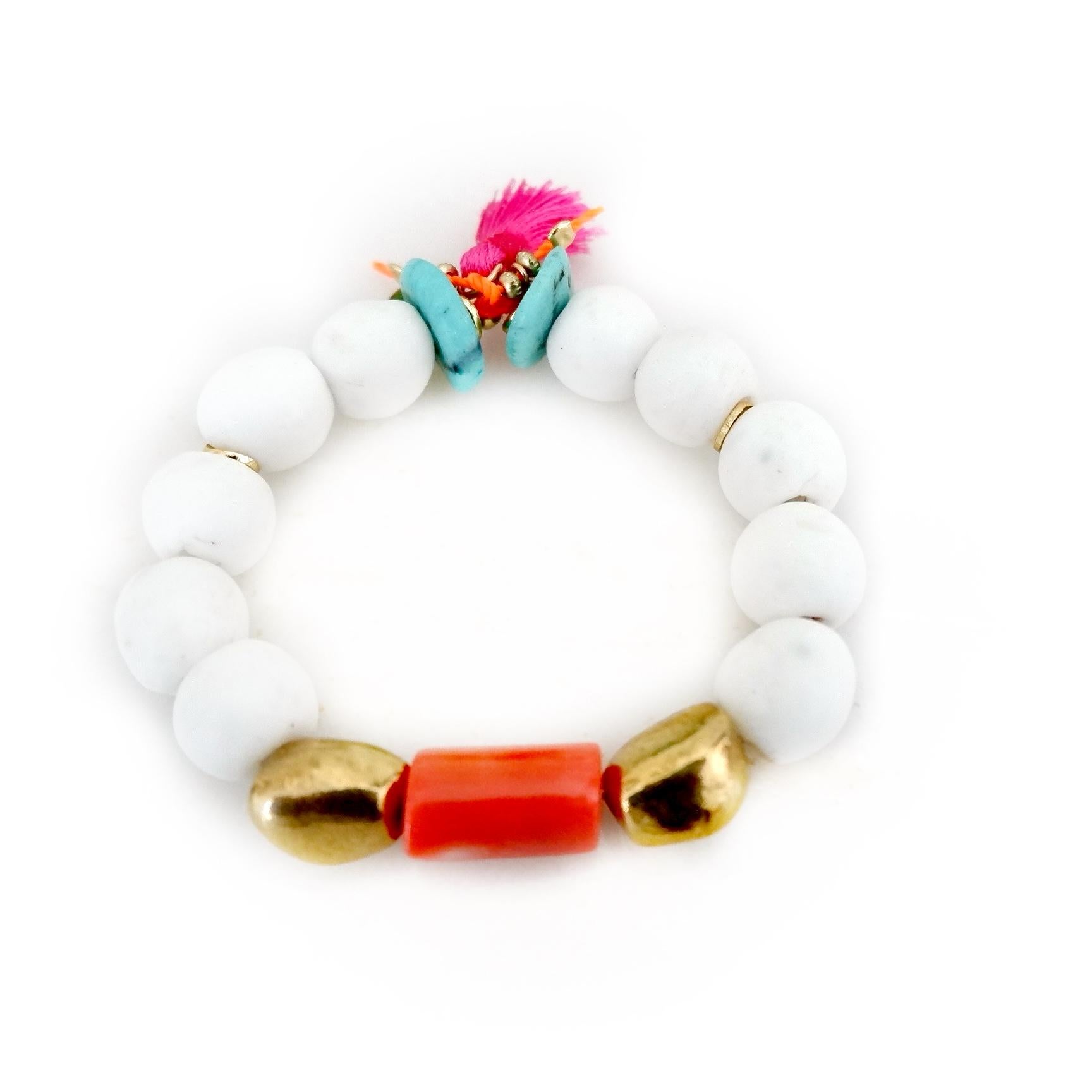 Discover a handcrafted, one-of-a-kind bracelet that brings together a captivating blend of textures and colors. This striking piece features chunky white matte African beads, known for their bold presence and unique texture. At its center, a vibrant