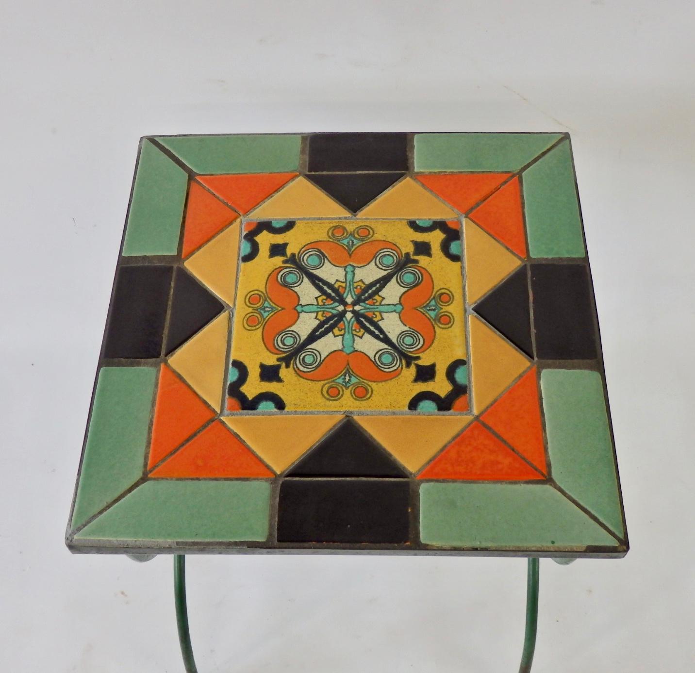 Beautifully colored California tile top table set into wrought iron base. Base in original green paint. Paint is worn.