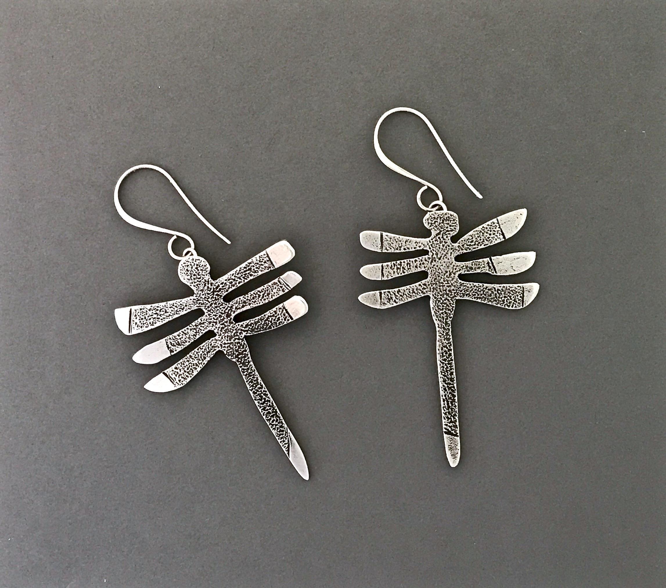 My Protectors, three-winged dragonfly earrings silver Navajo Melanie Yazzie

Melanie A. Yazzie (Navajo-Diné) is a highly regarded multimedia artist known for her printmaking, paintings, sculpture, and jewelry designs.

She has exhibited, lectured,
