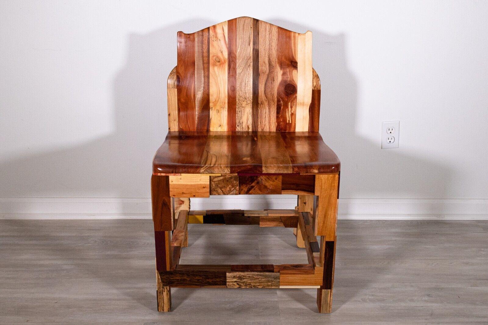 A truly unique handcrafted chair made with over 40 assortments of wood that is extremely well constructed and sturdy. The myriad of wood and grains creates layers of dimensions and design. Handcrafted by Michigan artesian Larry Buettner. Underside