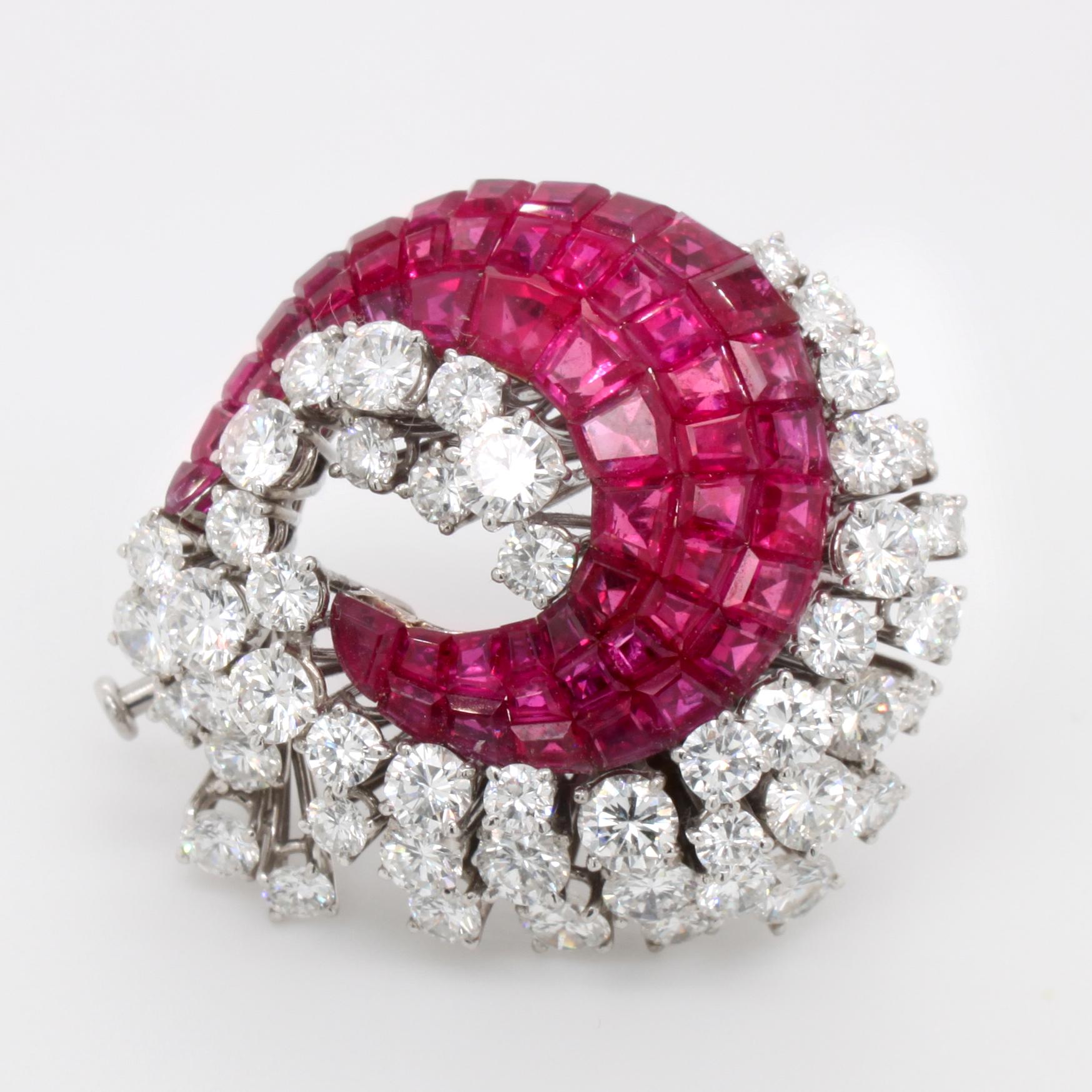 A ruby and diamond brooch in platinum, by the German jeweller Schilling. The rubies are mystery set with a very fine craftsmanship. They are surrounded by round brilliant cut diamonds of F/G colour and VVS/VS clarity, weighing approximately 5 carats