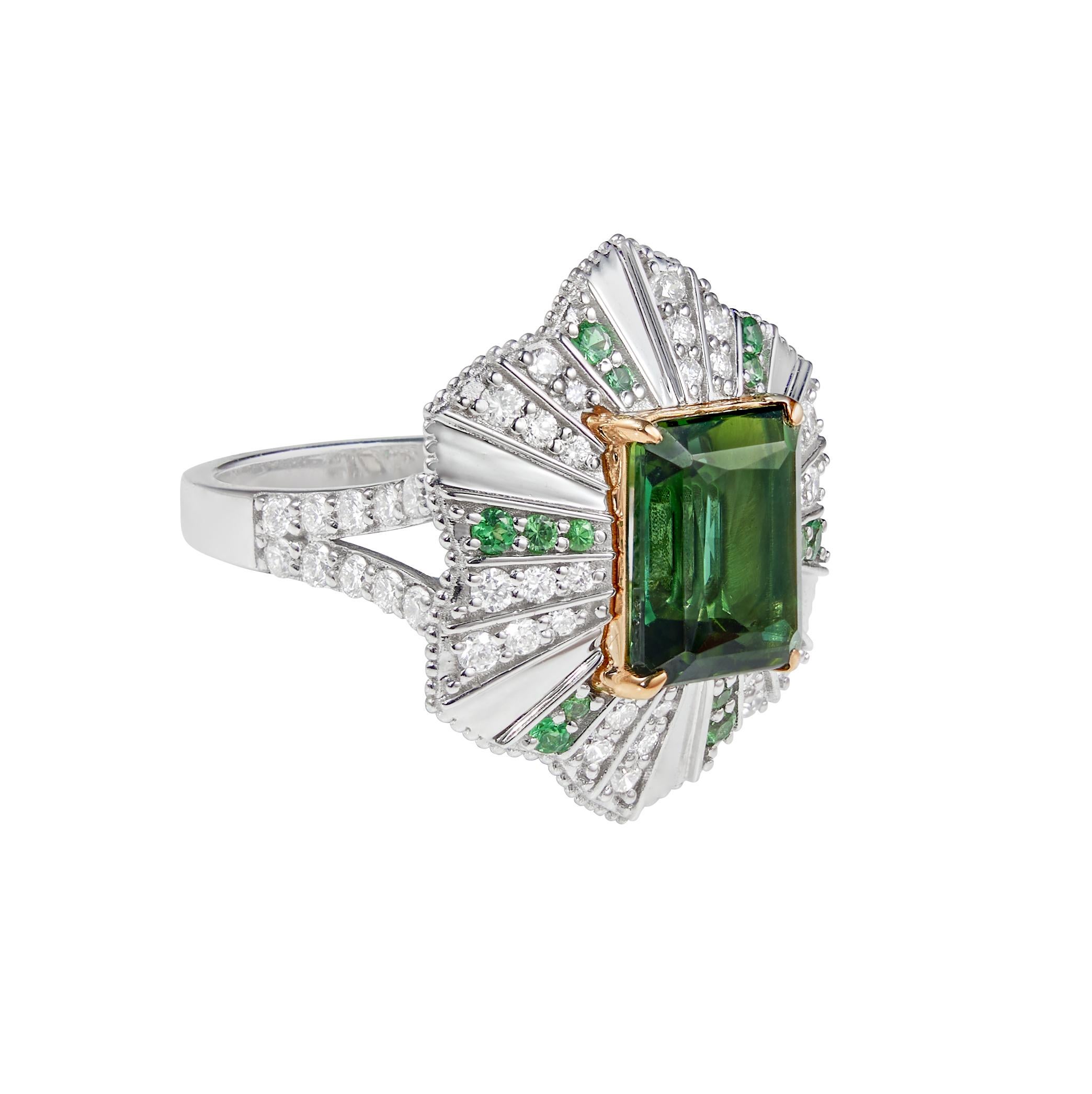 Mystic Green Tourmalines centred on an irregular frame of Tsavorites and Diamonds. Combined with subtle gold detailing the tourmalines are hypnotising with its deep green hue.

Mystic Green Tourmaline Ring with Tsavorites and Diamonds in 18 Karat