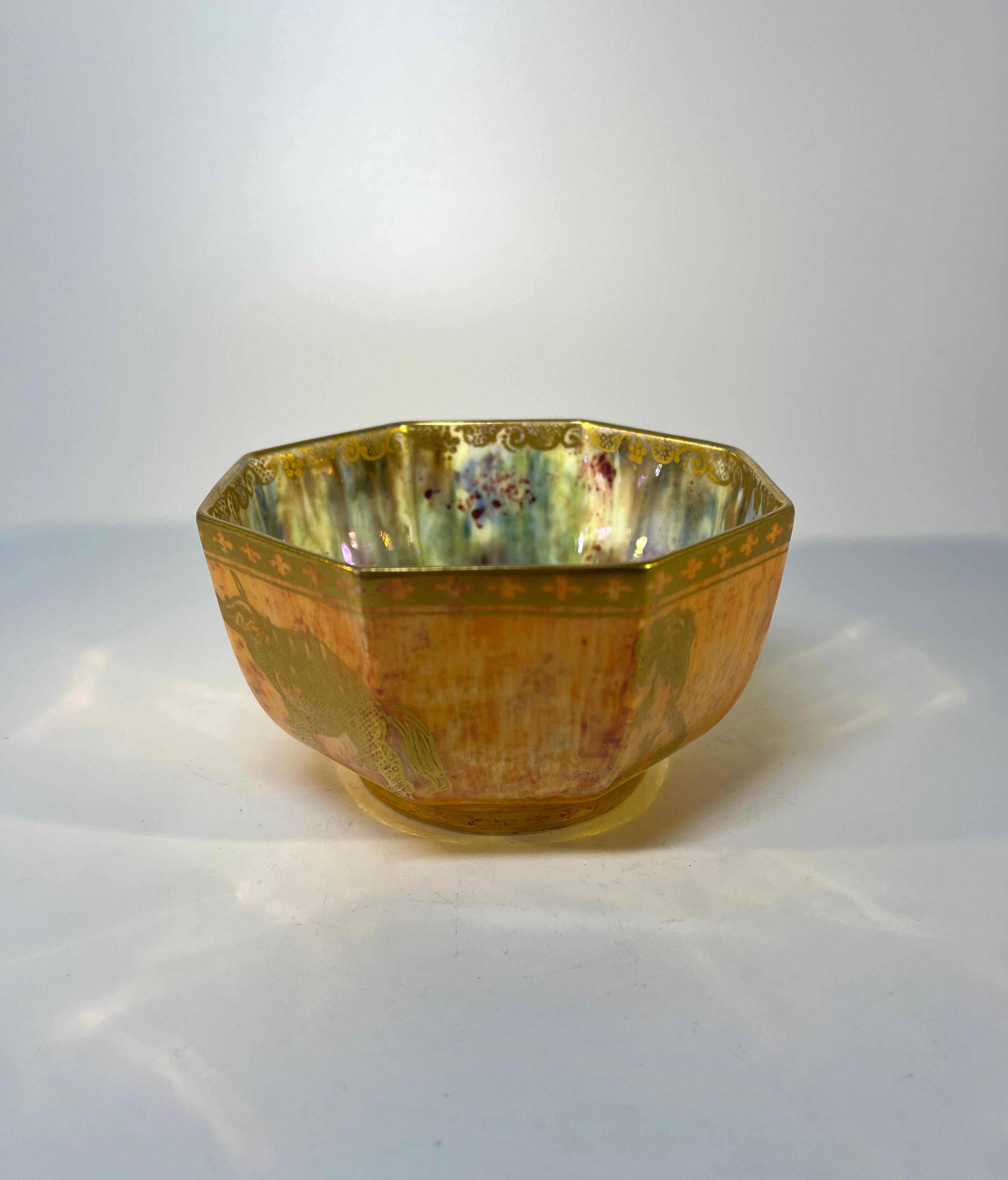 Sublime tangerine orange and gold lustre bowl by Daisy Makeig Jones for Wedgwood, England.
A fantastic menagerie of mystical creatures adorn the exterior of this exquisite piece. The interior has a ground of blue, cream and ruby mother of pearl