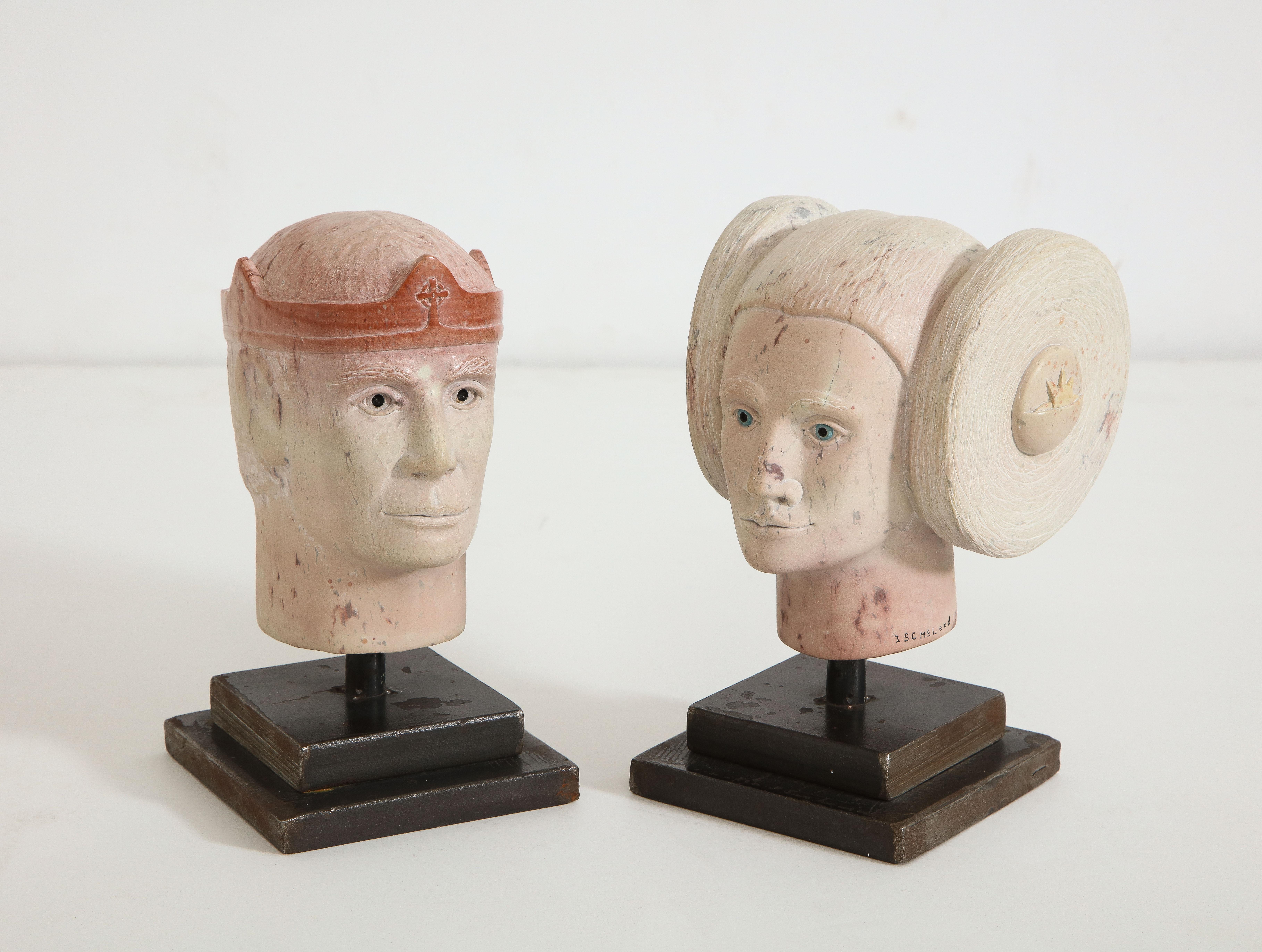 A very stylized pair of sculpted miniature granite heads depicting a mystical Prince and Princess, both signed ISC McLeod (for Scott McLeod) and dated 1996, mounted on stepped steel bases. 

Scott McLeod (b. 1952) is a self-taught Canadian