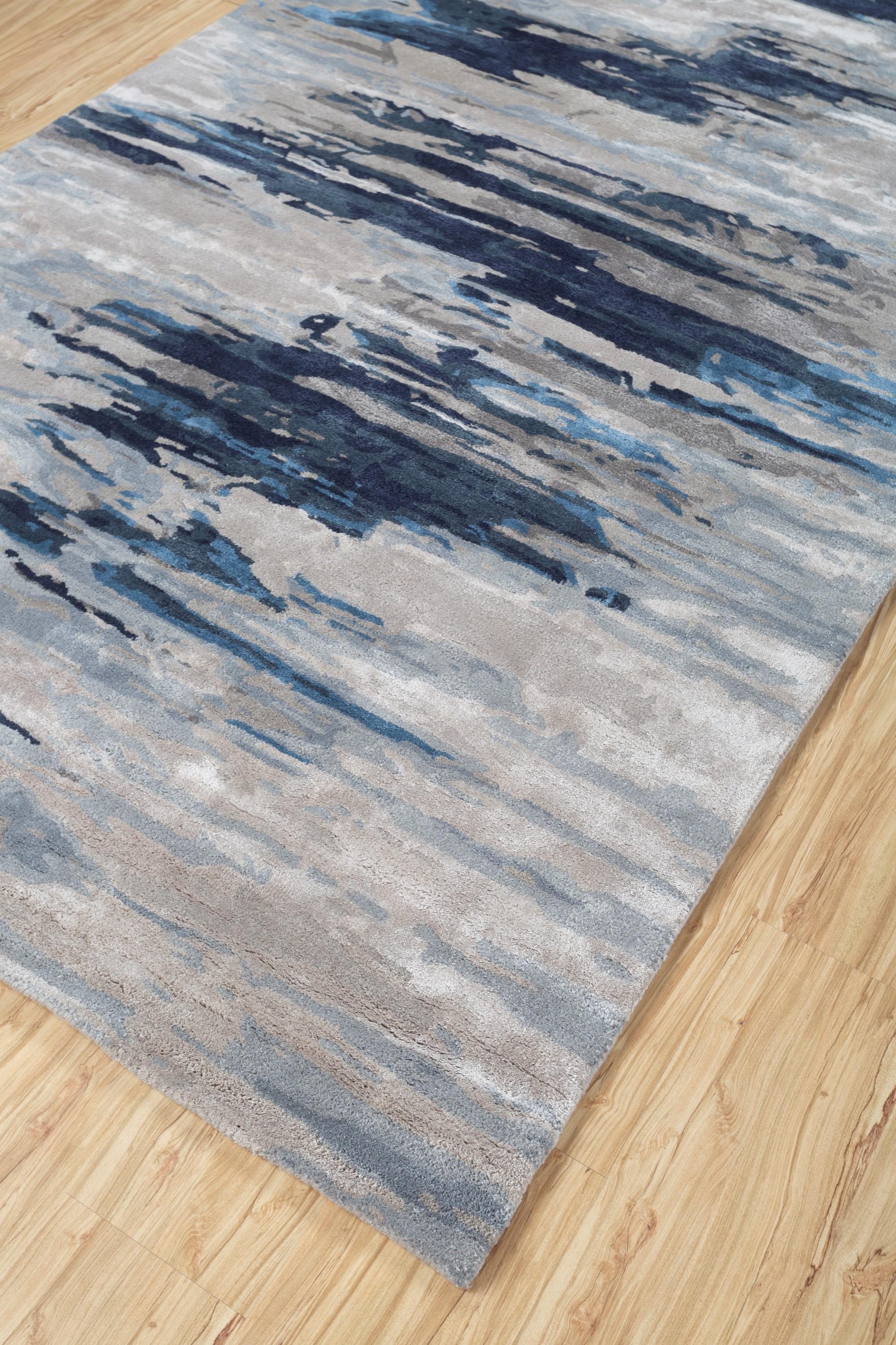 Imagine the cosmos unfolding beneath your feet with our Modern Hand-Tufted Rug, a celestial masterpiece reminiscent of a painting. The ethereal pastel hues blend like cosmic brushstrokes against the ashwood background, while indigo-blue borders