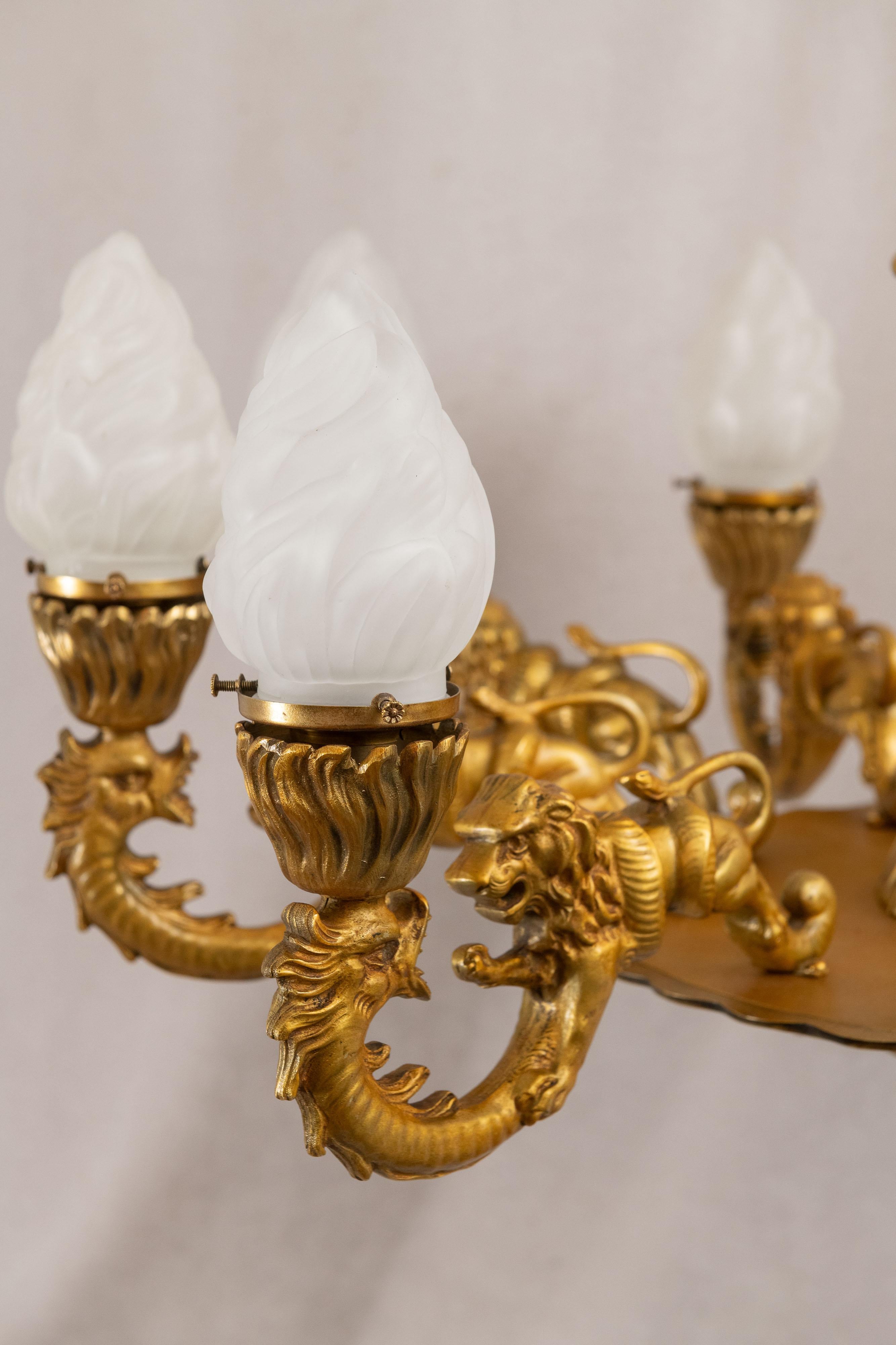 Tedesco Lampadario a 9 bracci in bronzo dorato con leoni, gargoyle e prometeo, 1890 ca. in vendita