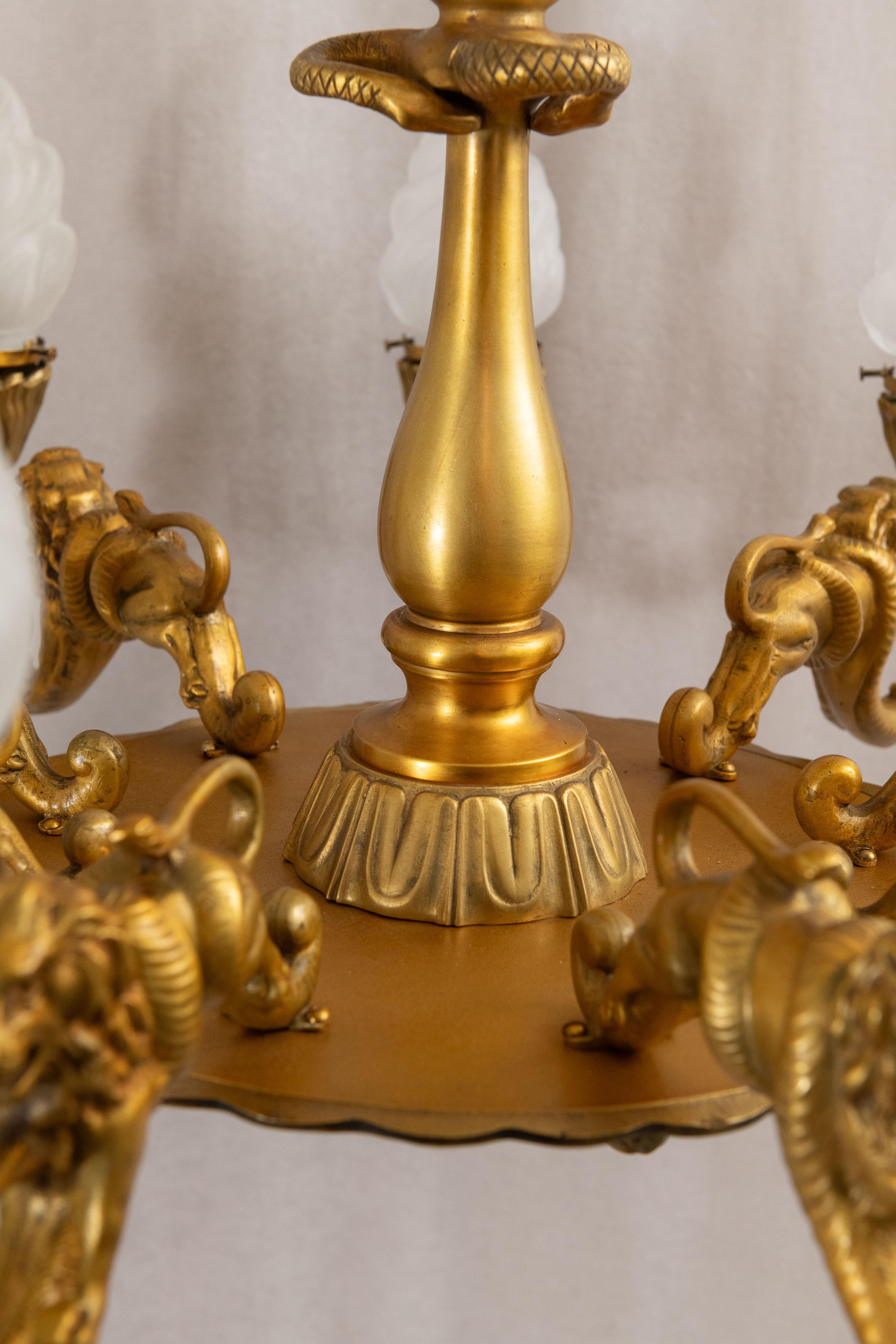 Dorato Lampadario a 9 bracci in bronzo dorato con leoni, gargoyle e prometeo, 1890 ca. in vendita