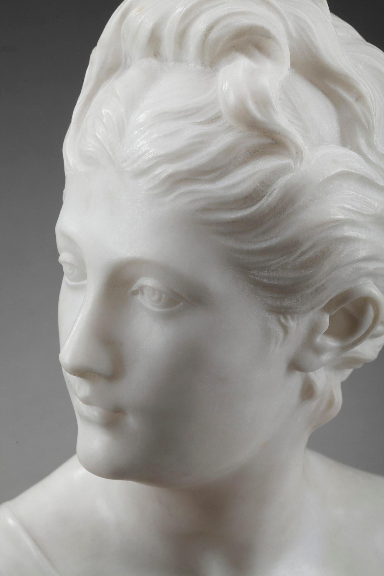 Late 19th century mythological bust crafted of alabaster featuring Diana, wearing a tunic that uncovers her breast. Diana (or Artemis) is commonly depicted as a tall and thin young huntress with her hair tied up and dressed in a tunic. Goddess of