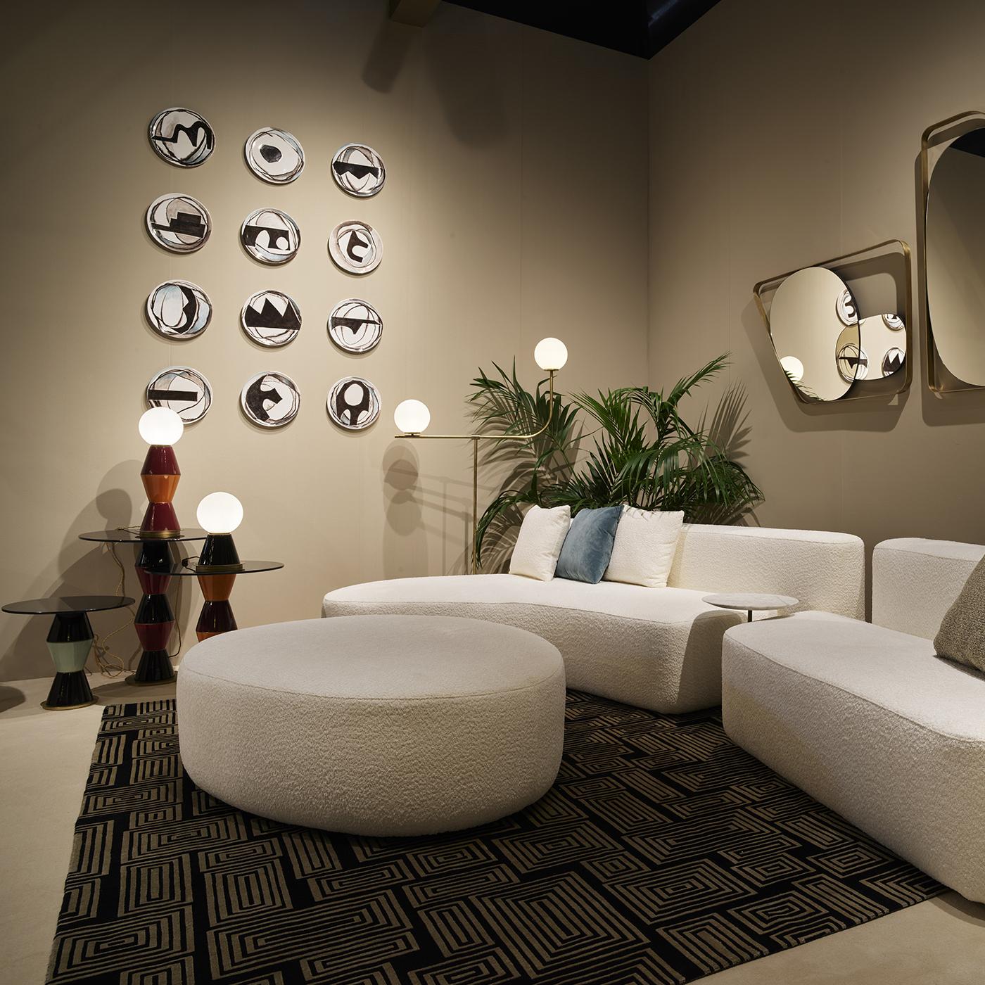 Dieses exklusive, zeitgenössisch inspirierte Sofa ist ein Triumph reicher Volumina, die von klaren Linien umrissen und von einem weißen Karan-Stoffbezug von zurückhaltender Eleganz verschlossen werden. Es können verschiedene Zubehörteile erworben