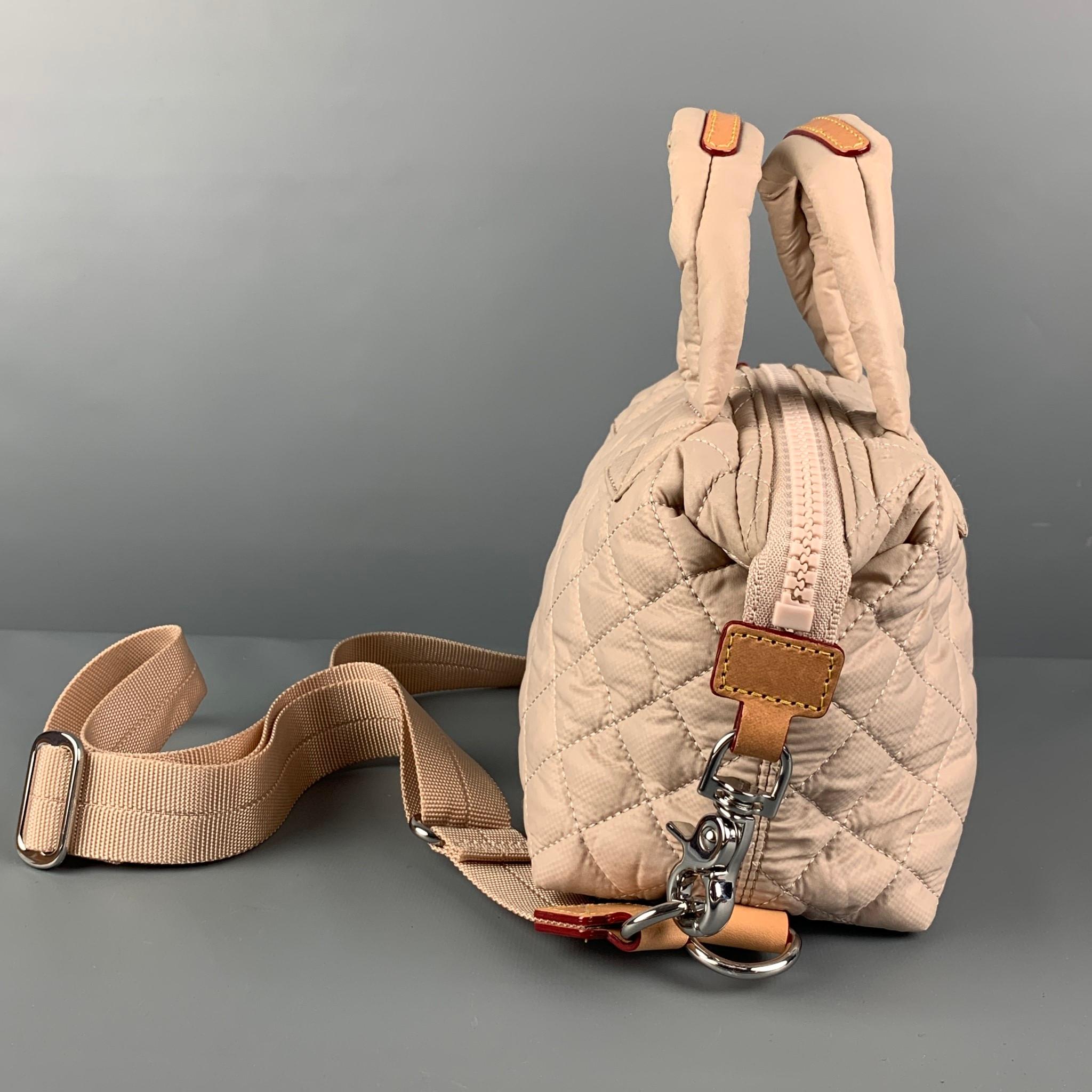 MZ WALLACE bag comes in a beige quilted nylon featuring top handles, leather trim, detachable cross body strap, inner pocket, and a top zipper closure. 

Very Good Pre-Owned Condition. Light mark at bottom.

Measurements:

Length: 6.5 in.
Width: 3.5