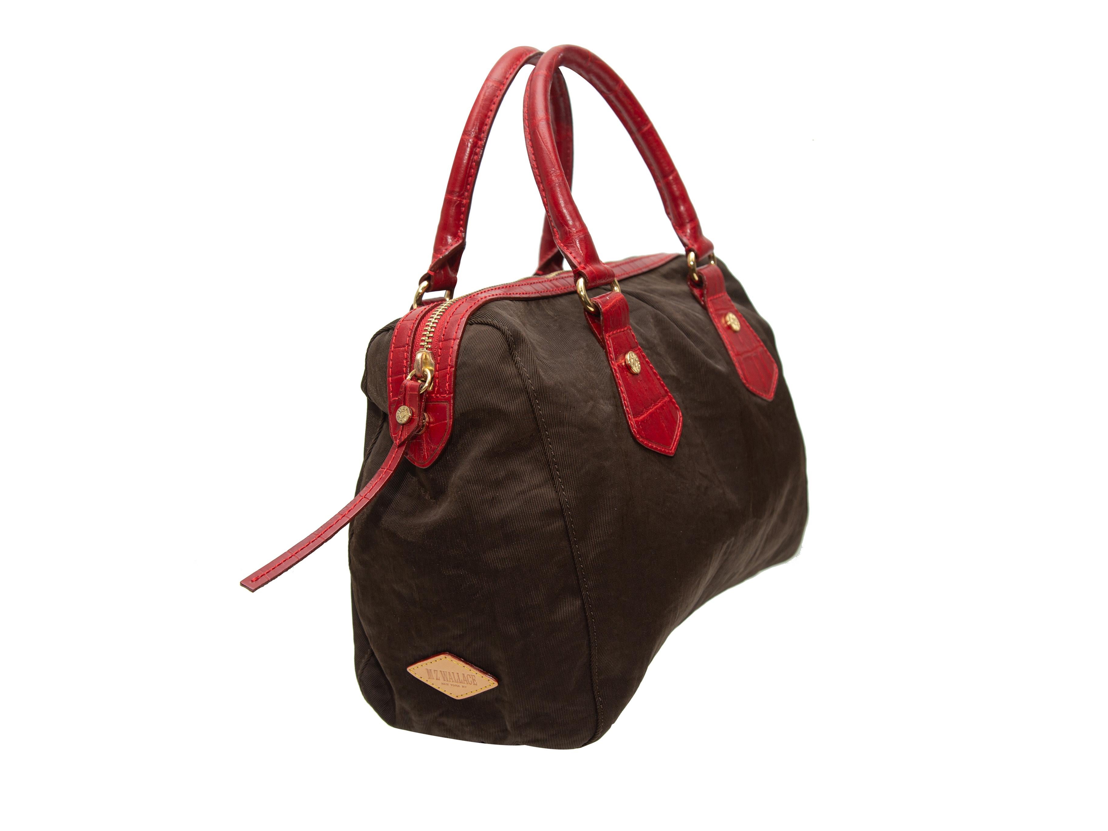 Product details: Brown fabric handbag by MZ Wallace. Red leather trim throughout. Gold-tone hardware. Interior zip pocket. Zip closure at top. 11.5