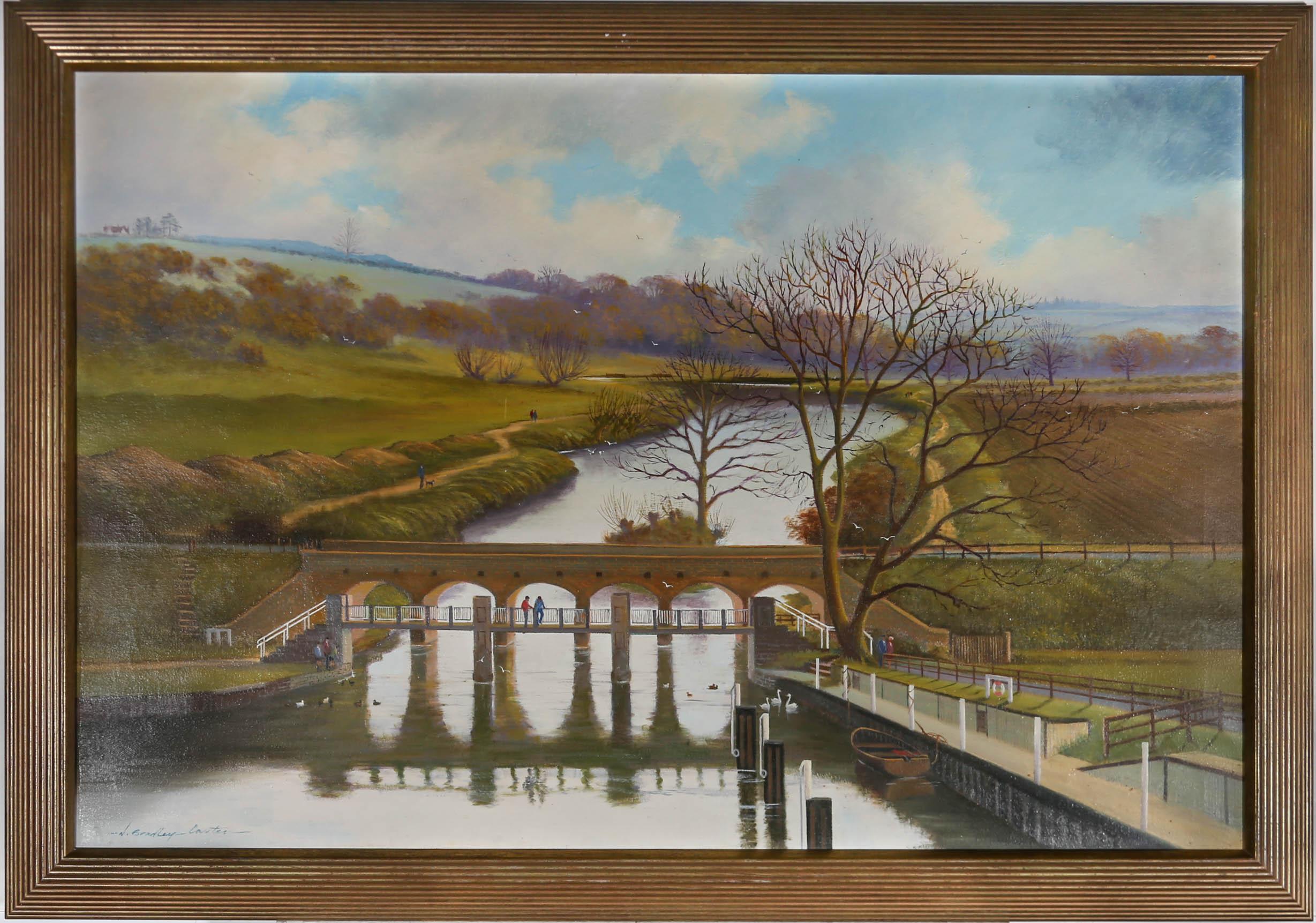 This charming oil depicts a picturesque river landscape, with country walkers either side of a disused railway bridge. Signed by the artist to the lower left. Well presented in a 20th century reeded frame. On canvas on stretchers. 