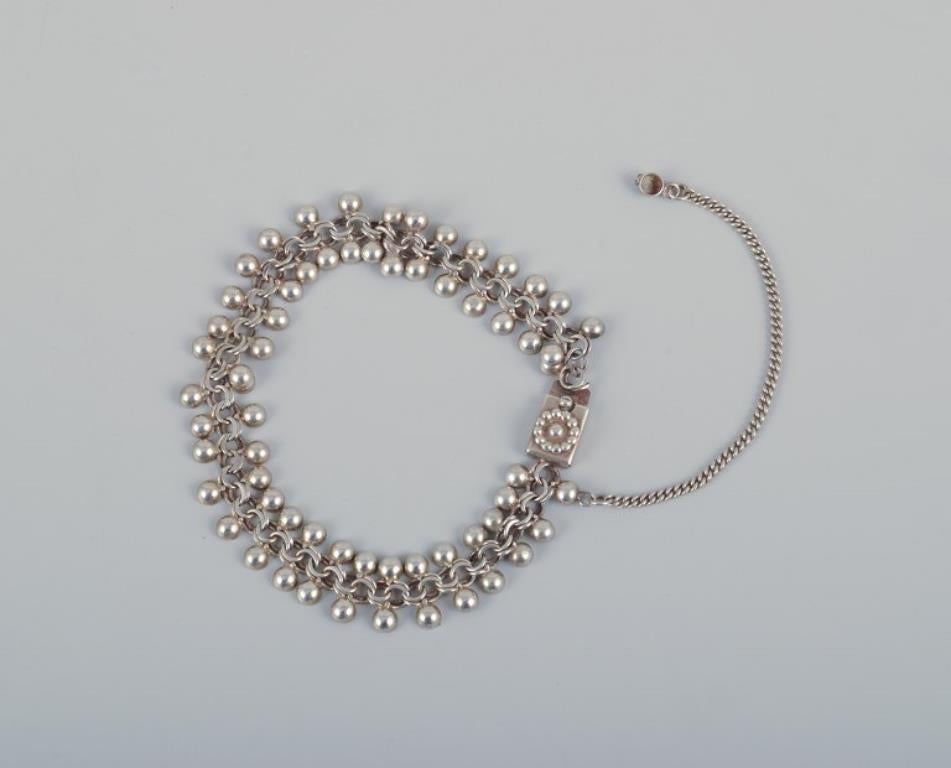 N. E. From and other Danish silversmiths. 
Three bracelets, one brooch, and two pendants in sterling silver and 830 silver.
1960s/70s.
Modernist design.
Marked.
Perfect condition.
Dimensions: Bracelets approximately 18 cm each.