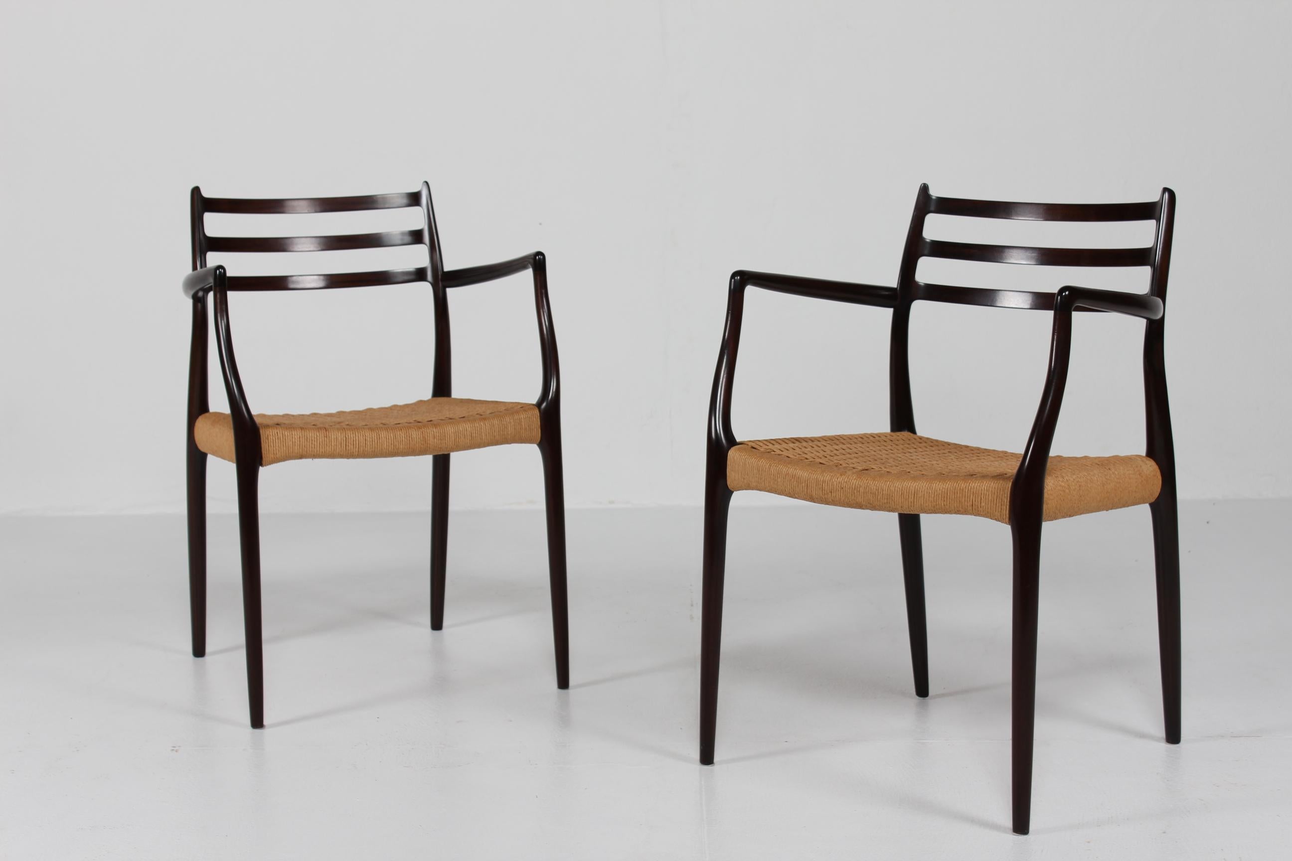 Here is a pair of armchairs, model no. 62, by the Danish cabinet maker and furniture designer Niels Otto Møller (1920-1982). 
They are manufactured in the 1960s by J. L. Møllers Møbelfabrik, Aarhus in Denmark.

The chairs are made of dark mahogany