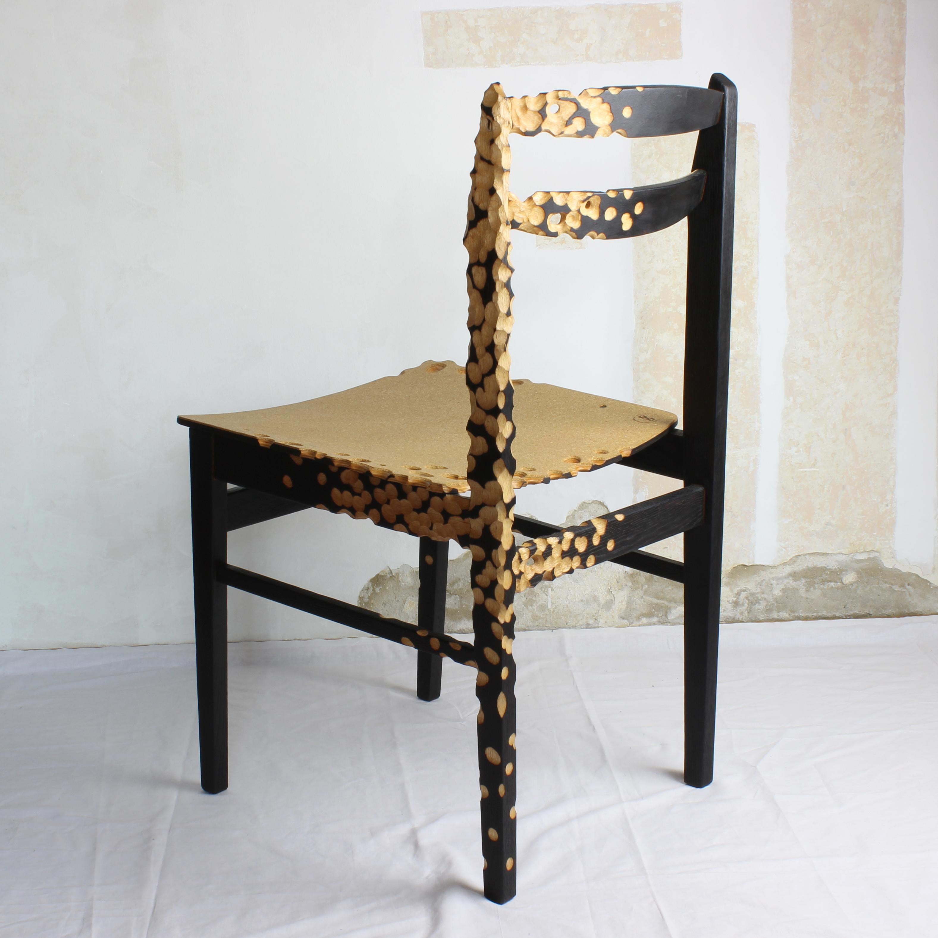 Sedia da pranzo N1 di Gabor Gobi
Un pezzo unico.
Dimensioni: P 46 x L 45 x H 83 cm.
Materiali: Legno di faggio bruciato, compensato e sughero.

Questa caratteristica sedia da pranzo, nata da un design di metà secolo, è stata reimmaginata utilizzando