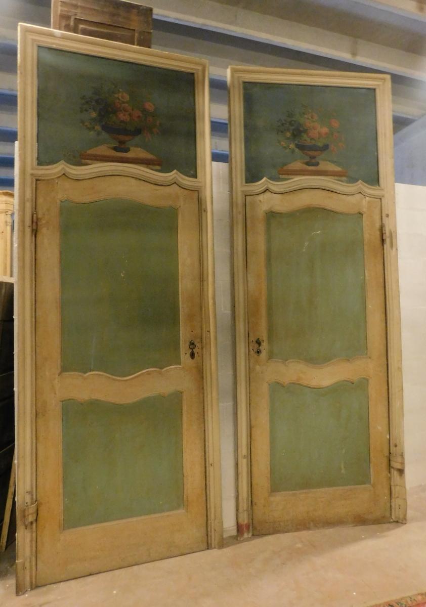 Set of two antique lacquered doors, painted front and back, with over door painted on canvas depicting a colorful floral bouquet, with sculpted panels and moved bar as typical of the construction period, hand-built in the mid-1700s, for an important
