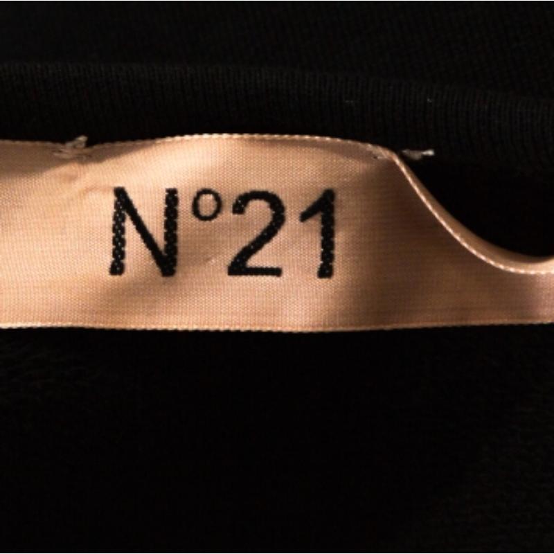 Un mix di comfort e alta moda: questo top di N21 è esattamente ciò di cui hai bisogno per essere al top del tuo stile. Questo attraente top nero ha bordi in pizzo con dettagli di occhielli sull'orlo e maniche lunghe. Realizzato in morbido cotone,