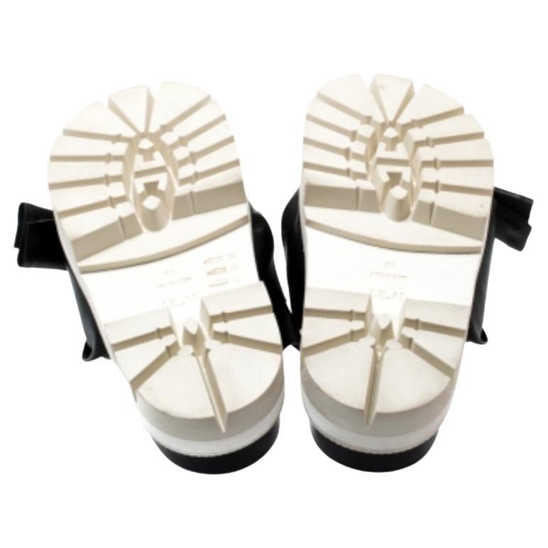 Questo paio nero perfeziona il tuo look con il suo stile unico. Queste diapositive di N21 sono realizzate in pelle e presentano un design a nodi sulla tomaia. Vengono forniti su piattaforme per un leggero sollevamento.