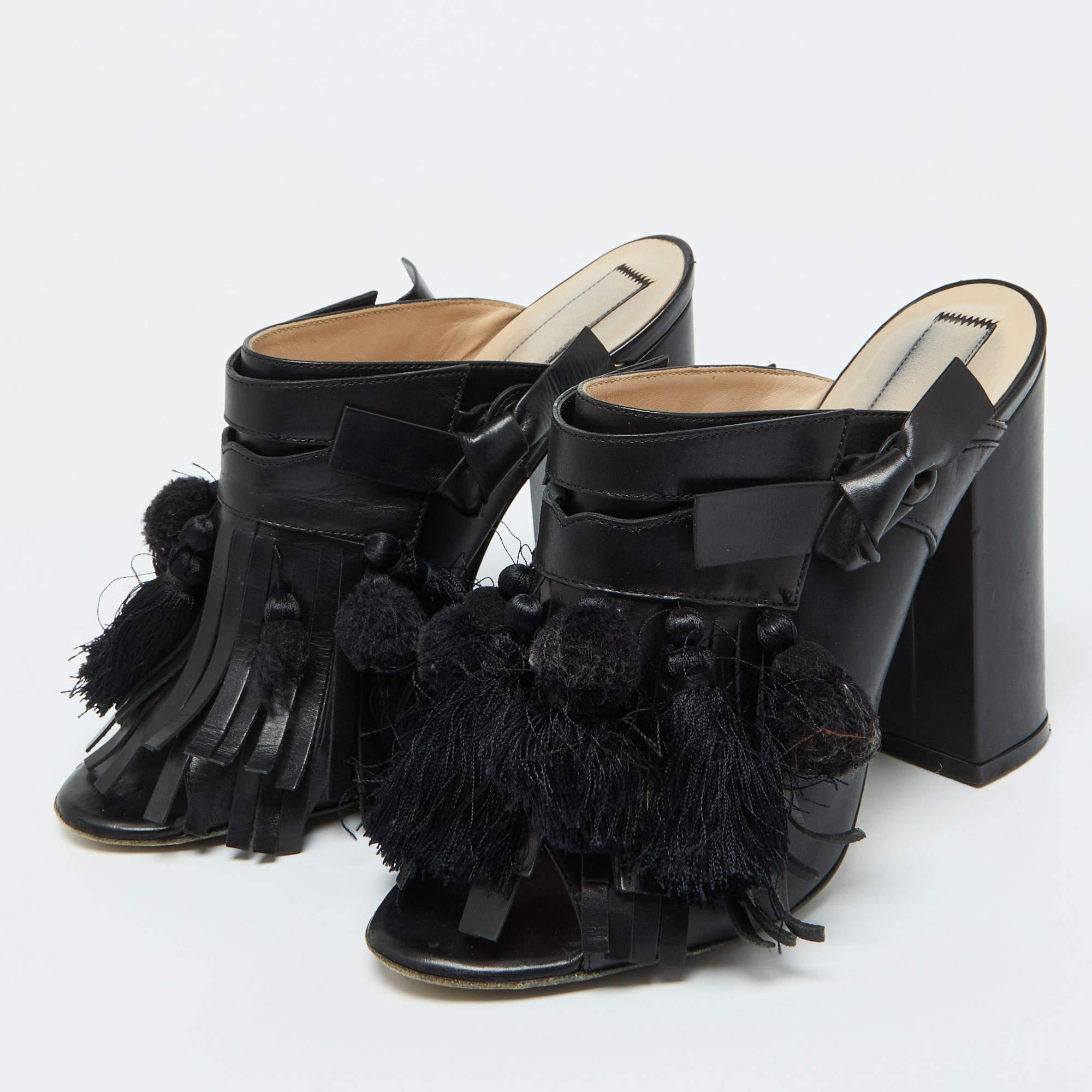 Caracterizadas por los detalles de borlas y flecos, las mules N°21 son un par de lo más llamativo y pueden llevar tu look a un nivel completamente nuevo. Están hábilmente confeccionadas en piel de color negro y tienen la puntera abierta. Estas mules