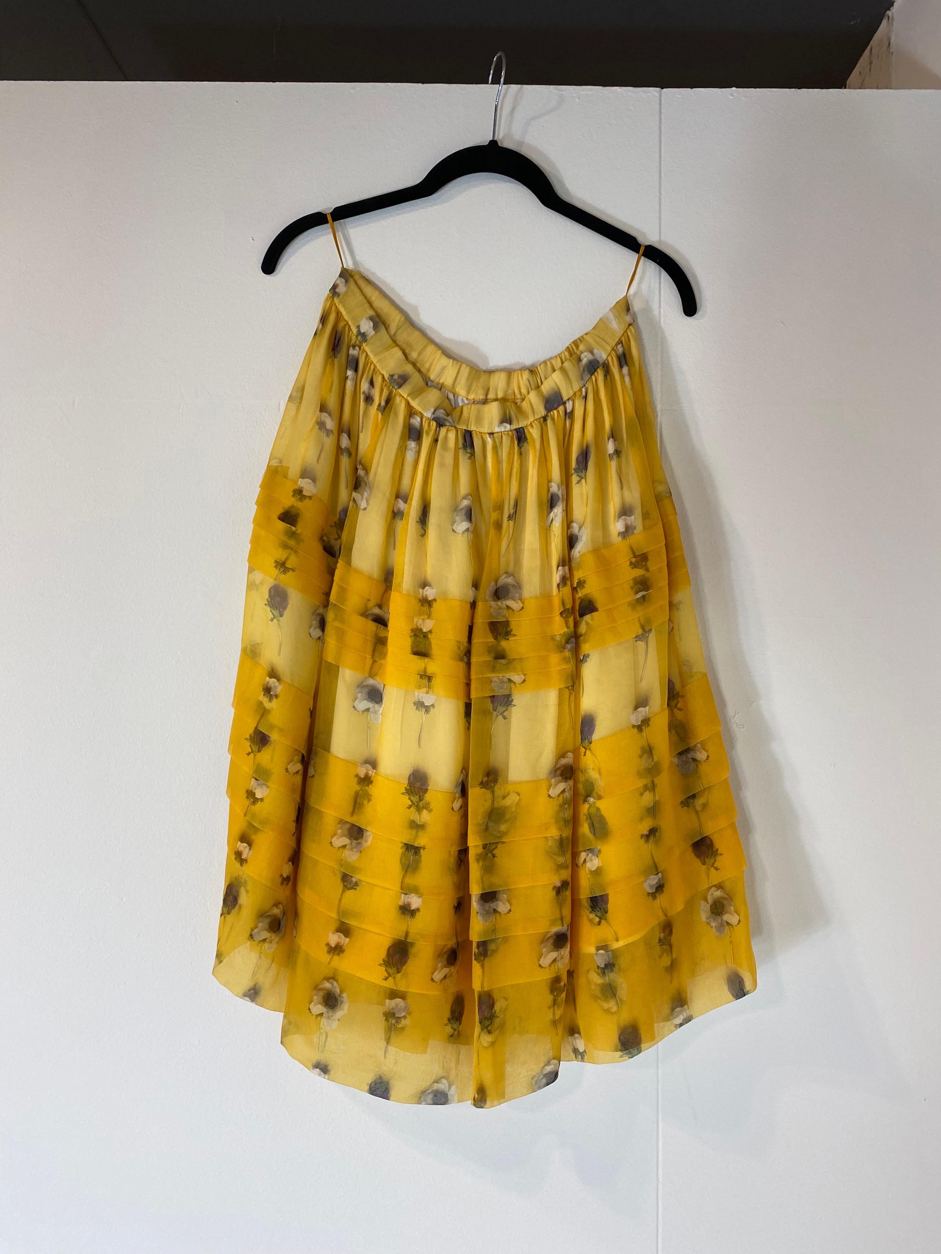 Falda midi N*21 de organza de seda, amarilla con motivos florales. 
Cintura ligeramente elástica. 
Con bolsillos laterales.
Forro blanco. 
Tiene señales de uso en la correa como en la foto pero en general está en excelentes condiciones. 
Talla 38