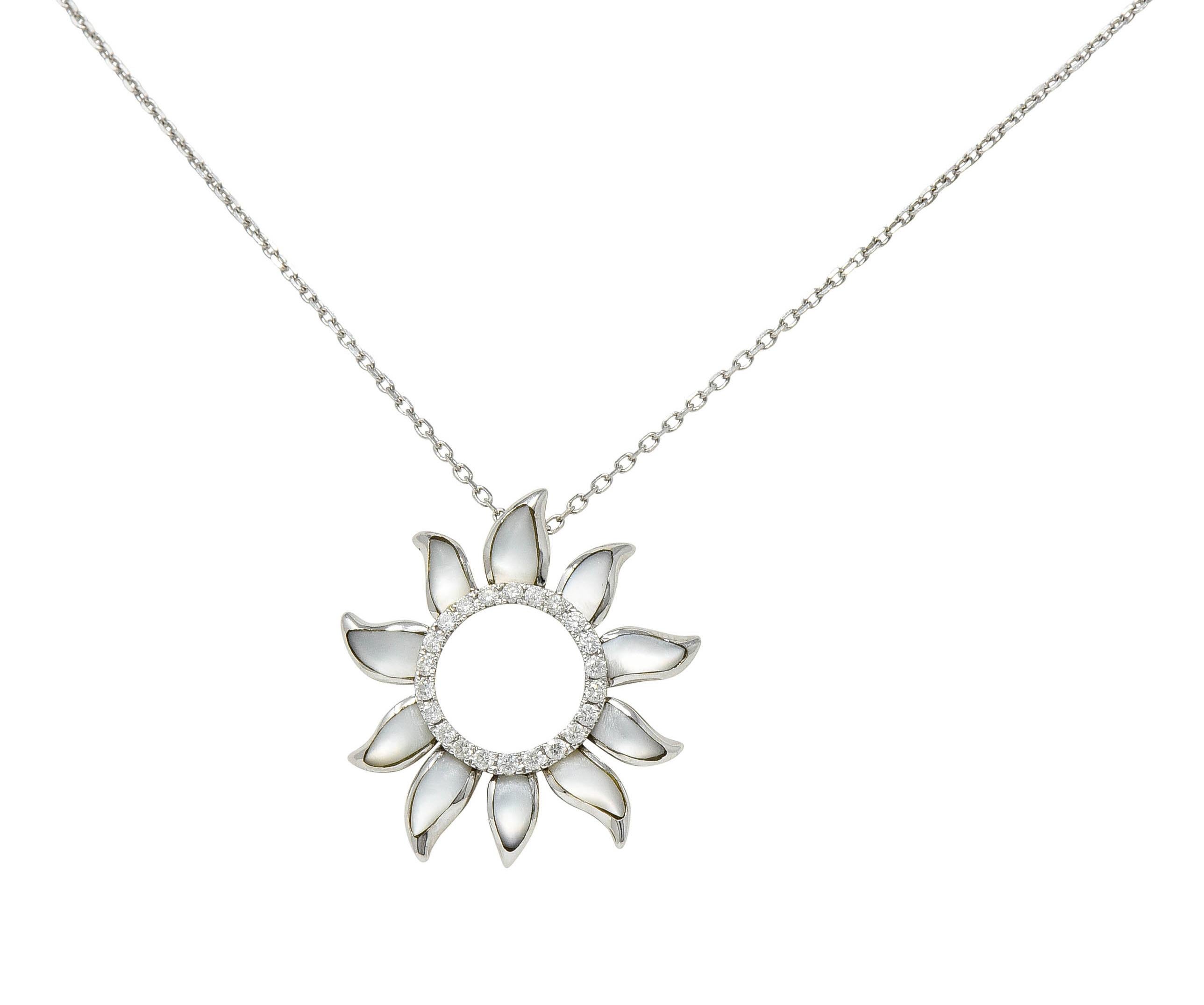 Cable chain necklace suspends a stylized sun pendant with an open center

Wavy sun rays are inlaid with white mother-of-pearl - exhibiting strongly white orient

With a halo of round brilliant cut diamonds weighing in total 0.21 carat - eye clean