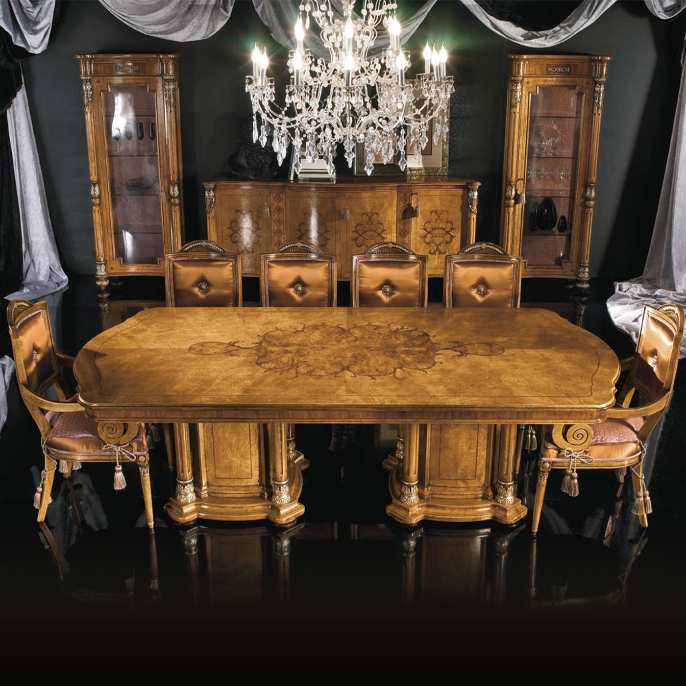 A showcase of deft craftsmanship paired with the charm of feathered ash wood, walnut briar, and rosewood defines the opulent personality of this dining table. The imposing top, richly decorated with fancy and distinctive marquetries, features smooth