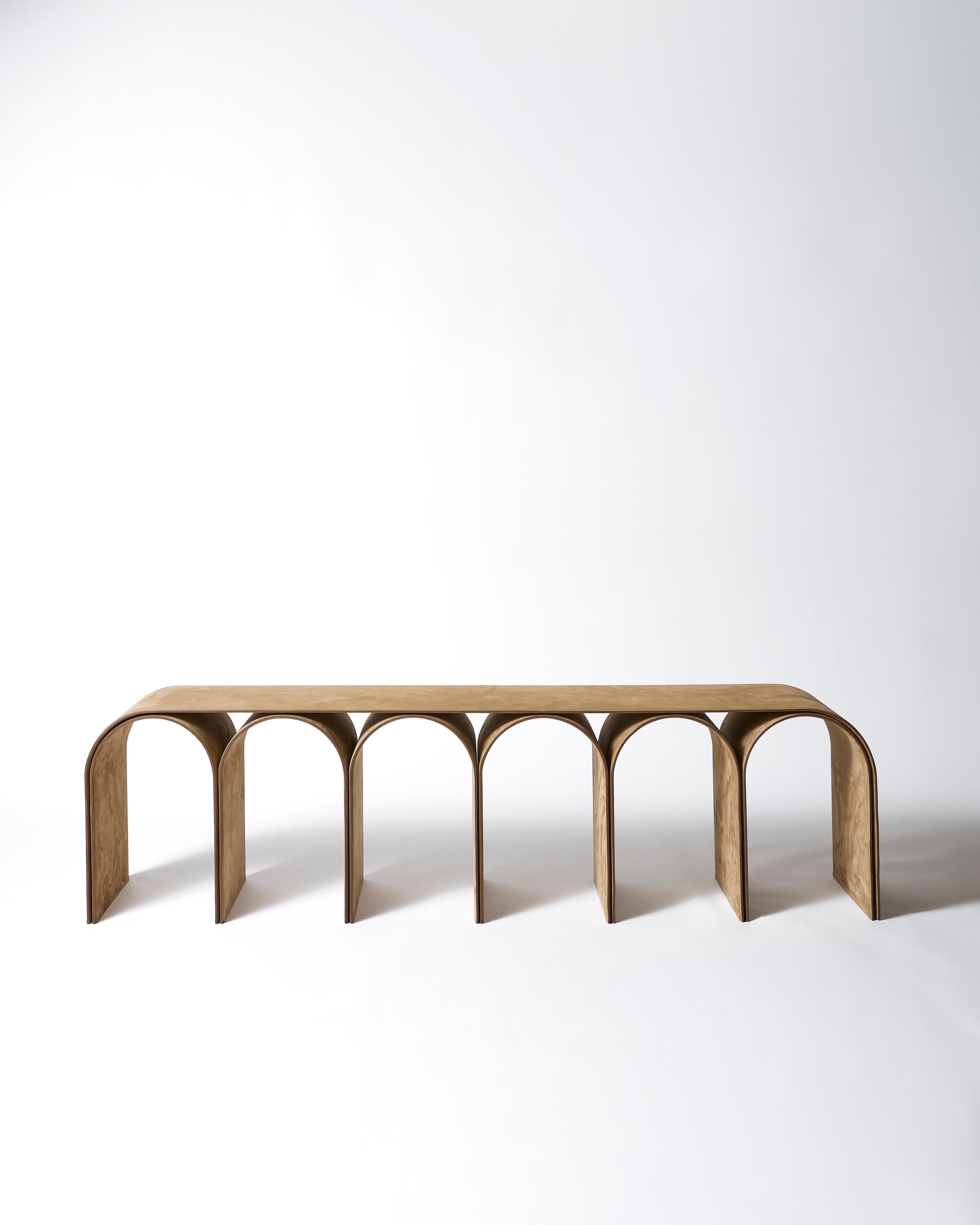 Nabuk Gold Arch Bench by Pietro Franceschini
Materials: Nabuk.
Dimensions: W 155 x L 33 x 43cm.
Manufacturer: Prinzivalli.

Available finishes:
Steel (black, white, brass finish)
Aluminum (silver finish)
Brass (satin, semi-polished,
