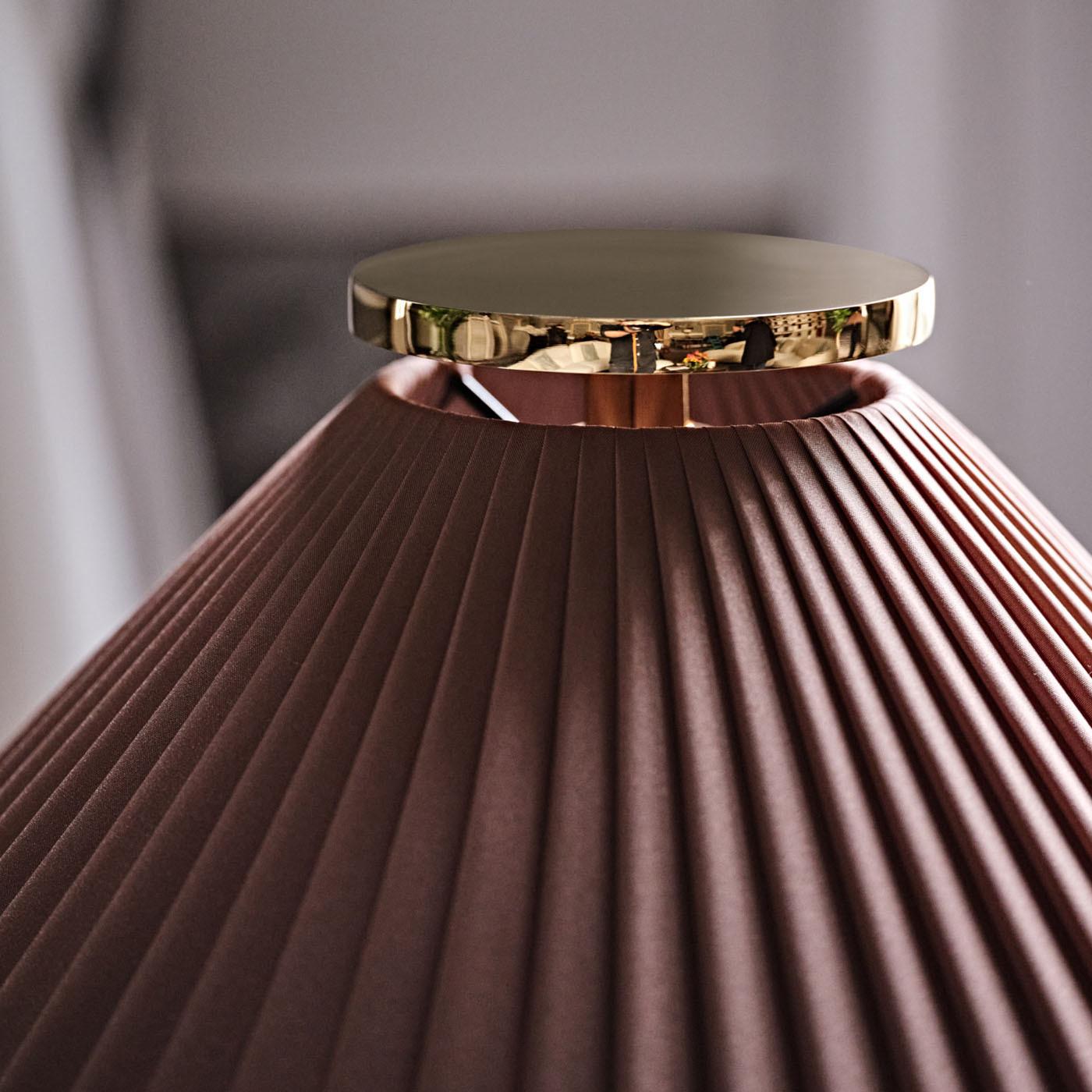 An extraordinary ensemble of geometric shapes, this elegant table lamp emits diffused or downward lighting. A classic silhouette revisited in an innovative, contemporary key, it features a blue-black glossy-lacquered wooden base and a pleated,