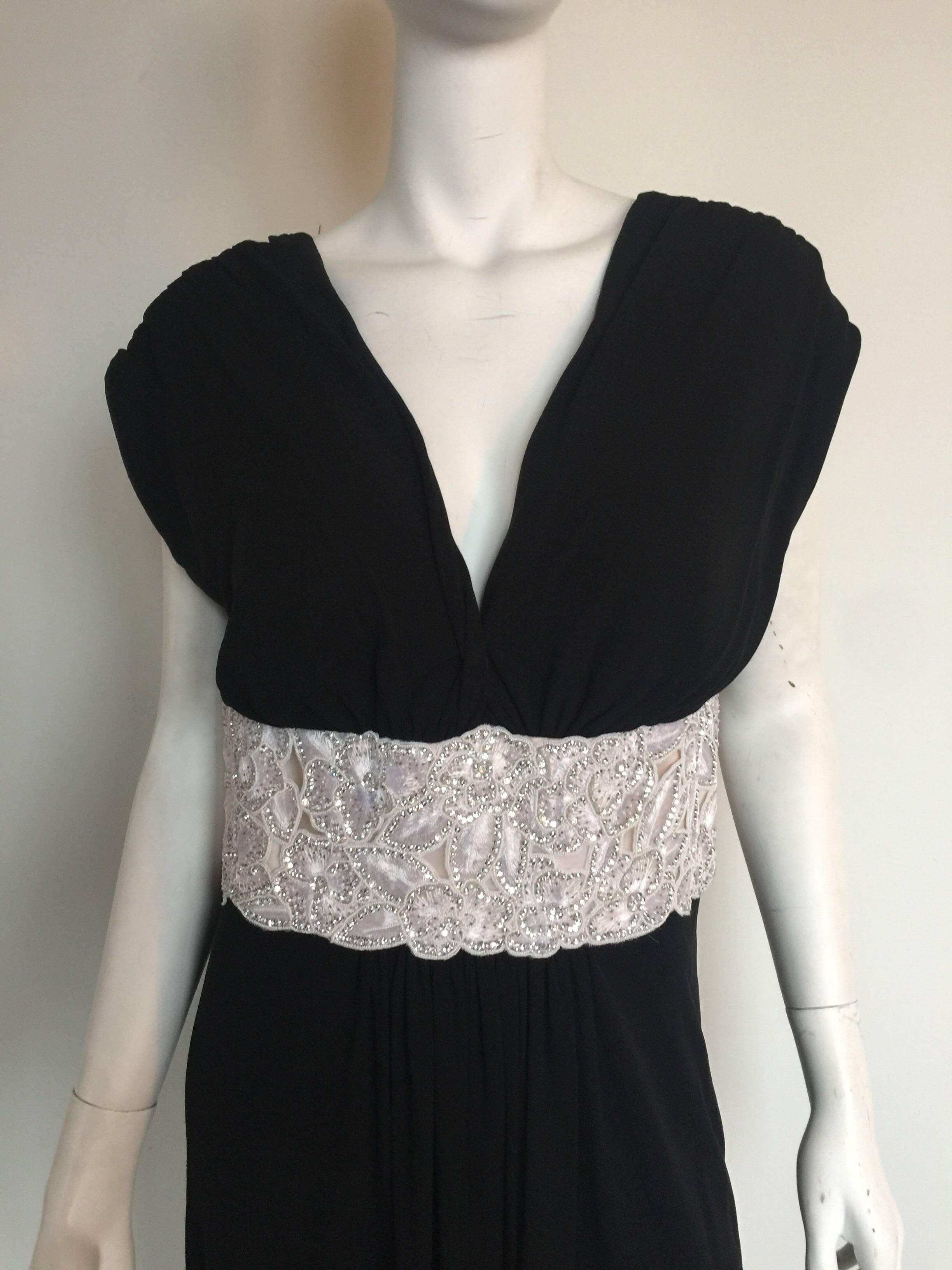 This custom made black silk jersey gown has an intricate white lace and crystal embroidered waist band.  It is in excellent condition.  The dress has a zipper and snaps in the back and built in cups