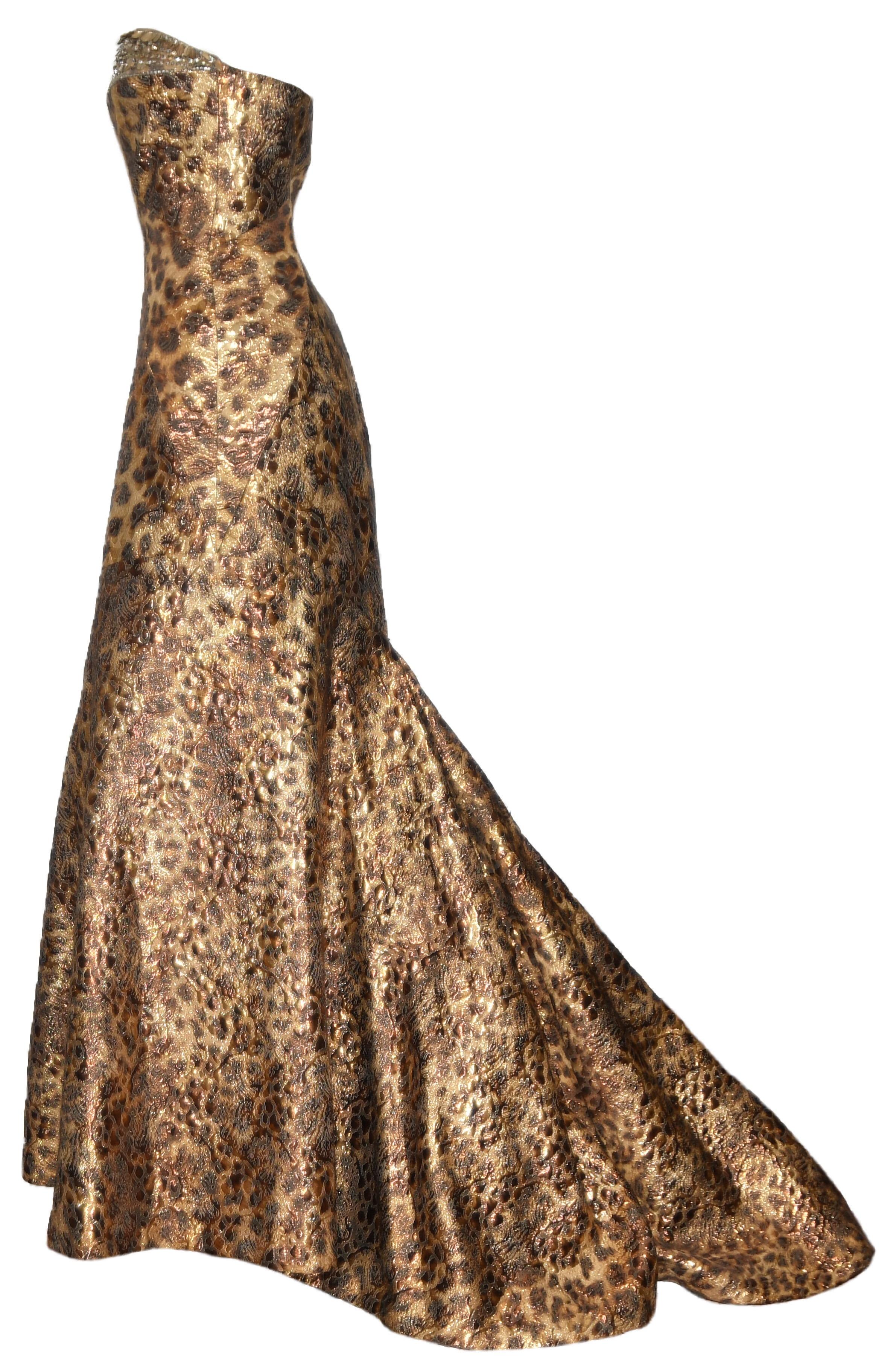 Naeem Khan leopard print brocade gown in luxurious gold tone threads is intertwined with copper tone lame.   The bodice is trimmed at the bust by crystals, beads and metal accents in gold tone.  This strapless gown culminates in a grand gathered
