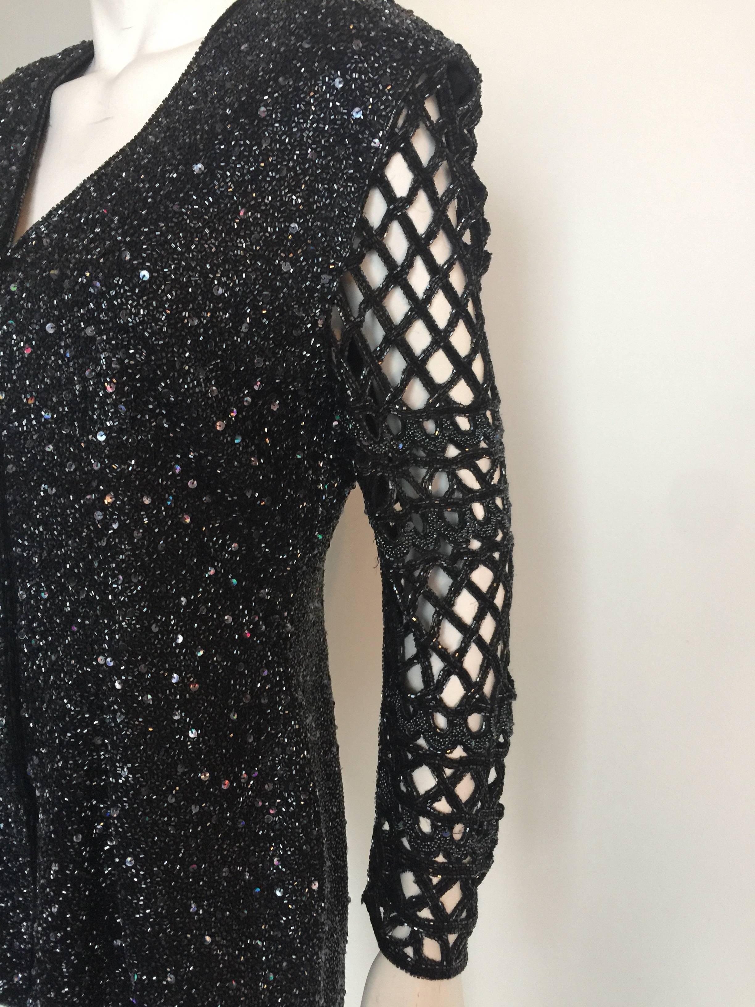 Thi fully beaded black jacket has a beaded cut out design sleeve and a front zipper.  It is a unique piece.  It is in excellent condition and in the light the black beading almost looks charcoal grey.  