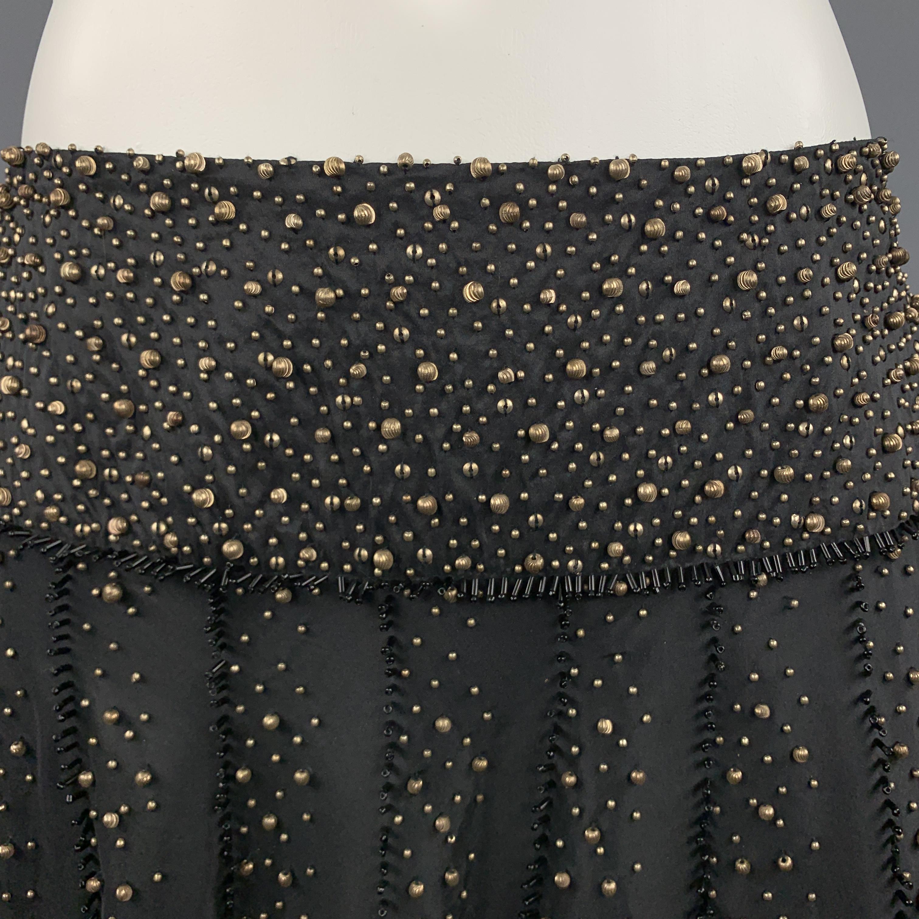 NAEEM KHAN A line skirt comes in black silk taffeta gold tone beadwork throughout and black bugle bead piping. Made in USA.

Excellent Pre-Owned Condition.
Marked: US 6

Measurements:

Waist: 29 in.
Hip: 60 in.
Length: 25 in.