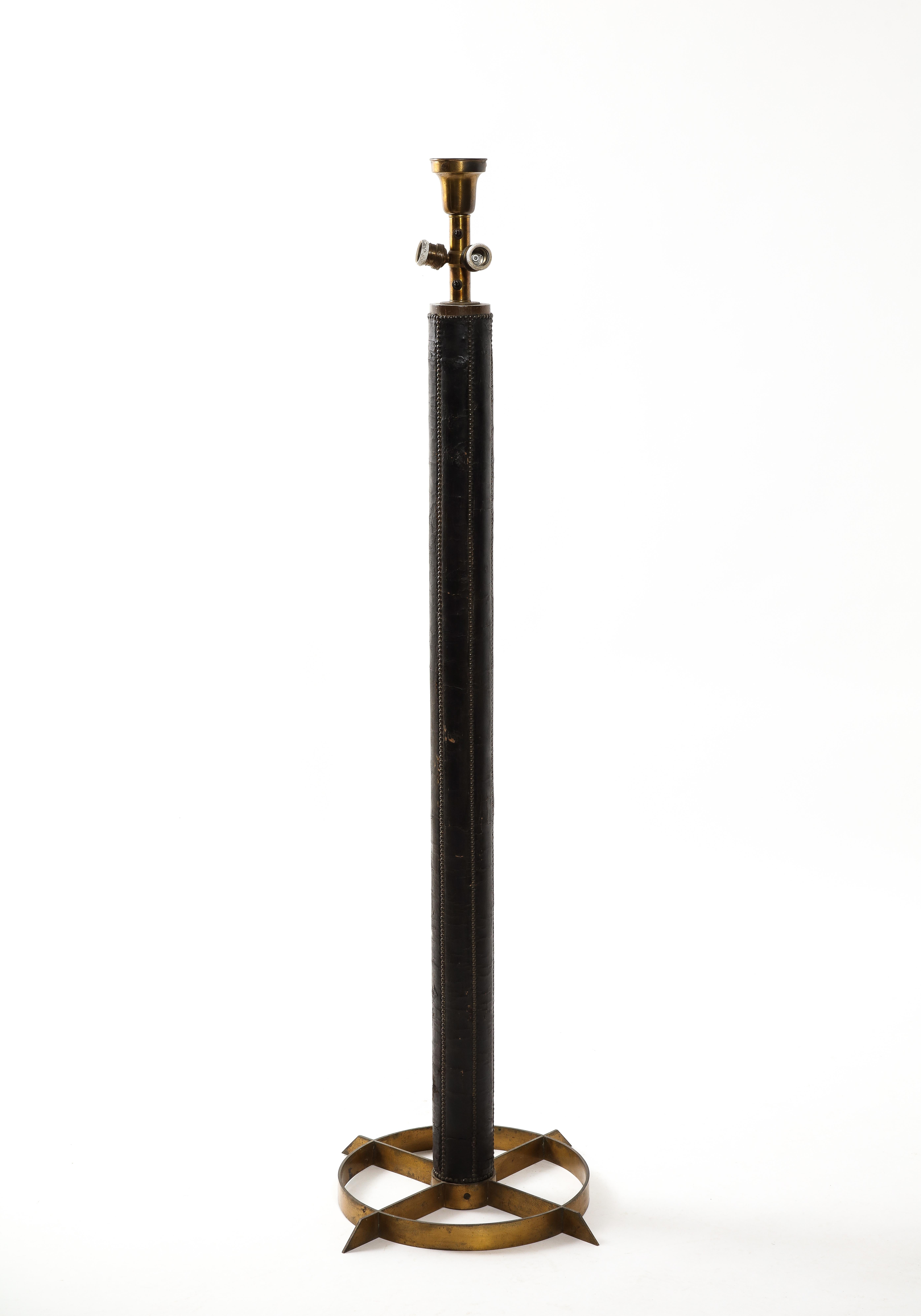Distinctive nail-studded leather floor lamp on a circular bronze base, great patina.