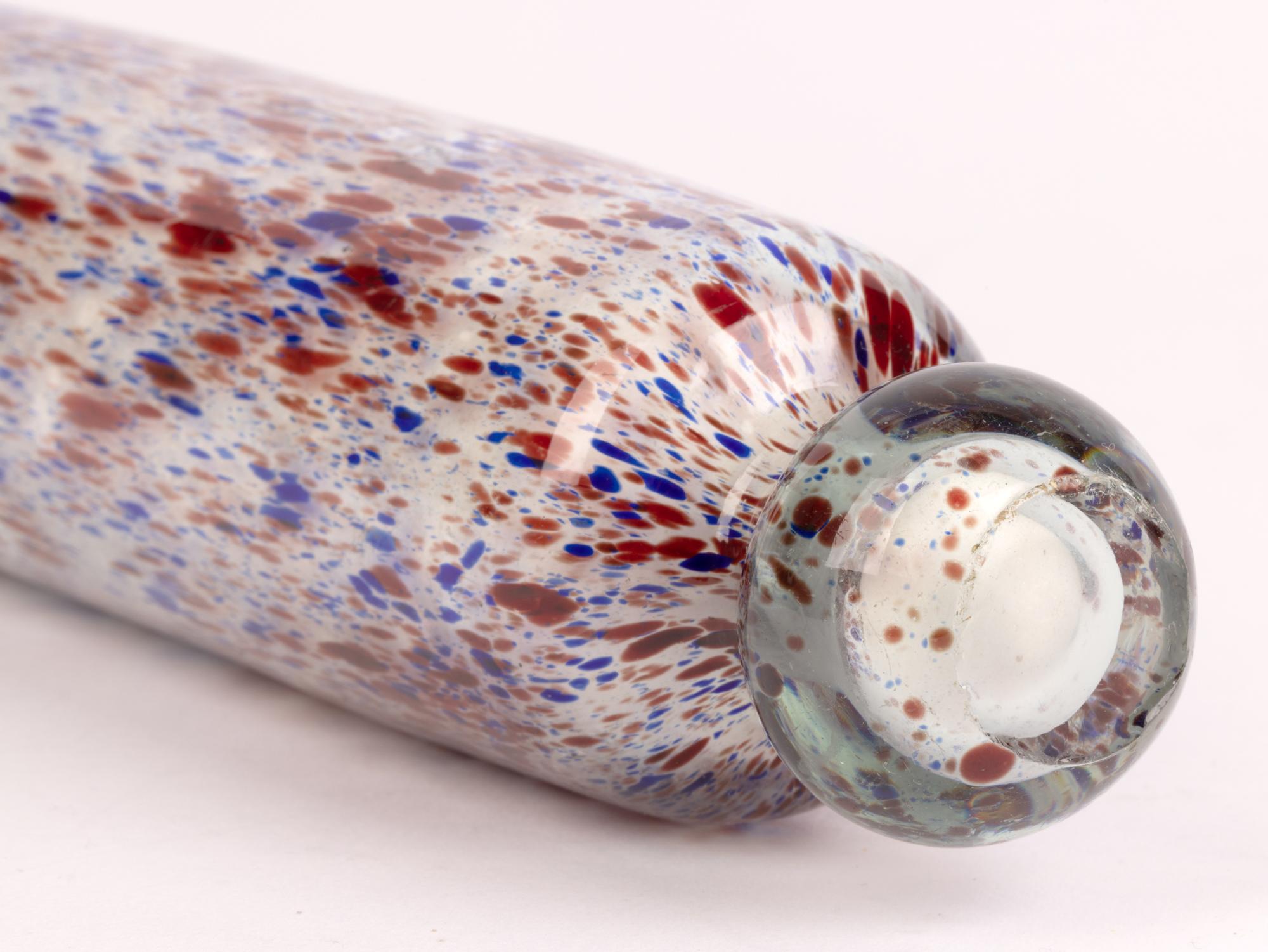 A good Nailsea Victorian glass rolling pin with colored glass inclusions dating from the 19th century. The heavily made and hollow blown glass rolling pin has been made in clear glass with a white glass interior and with a spatter pattern of blue