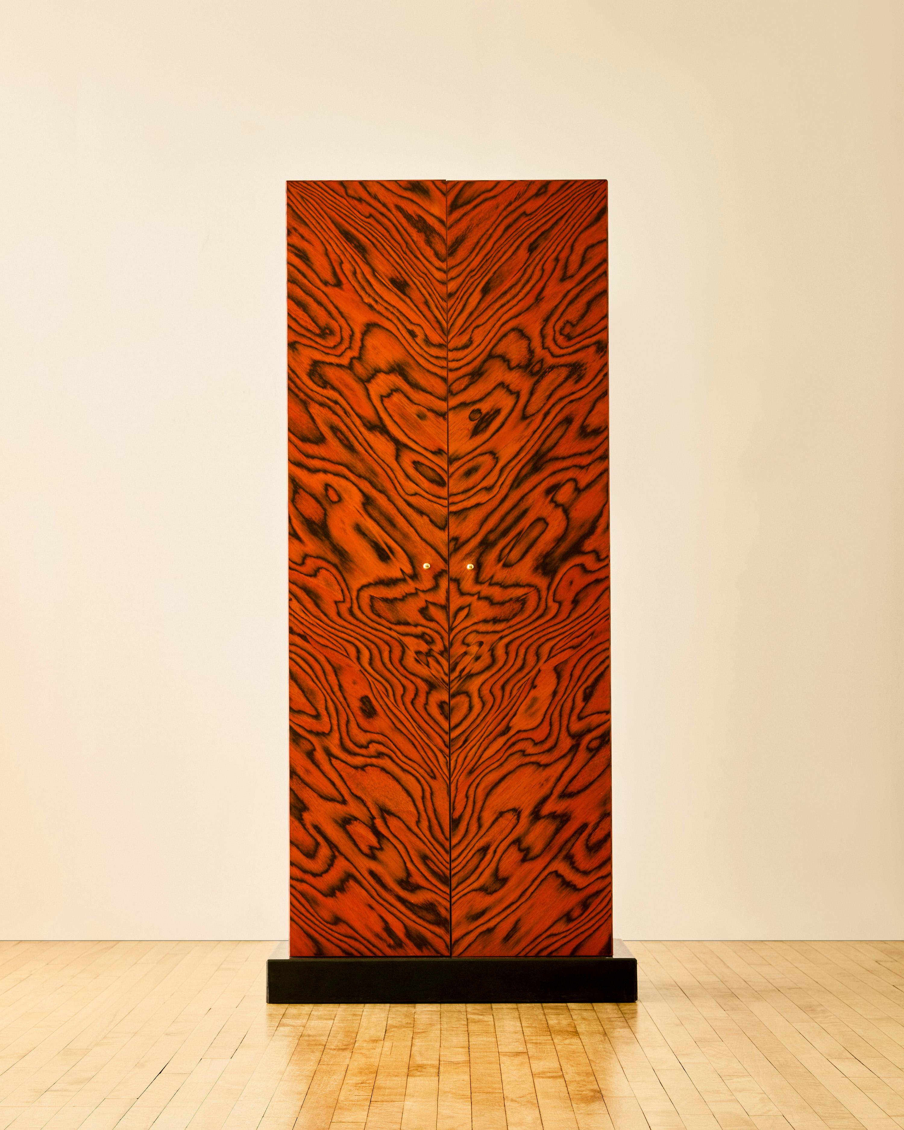 Nairobi bar cabinet by Ettore Sottsass for Zanotta in a red ebonized and aniline-dyed wood and signed to upper left side 'Ettore Sottsass'. The cabinet features two doors concealing one shelf, one drawer, and a drop-front surface with brass