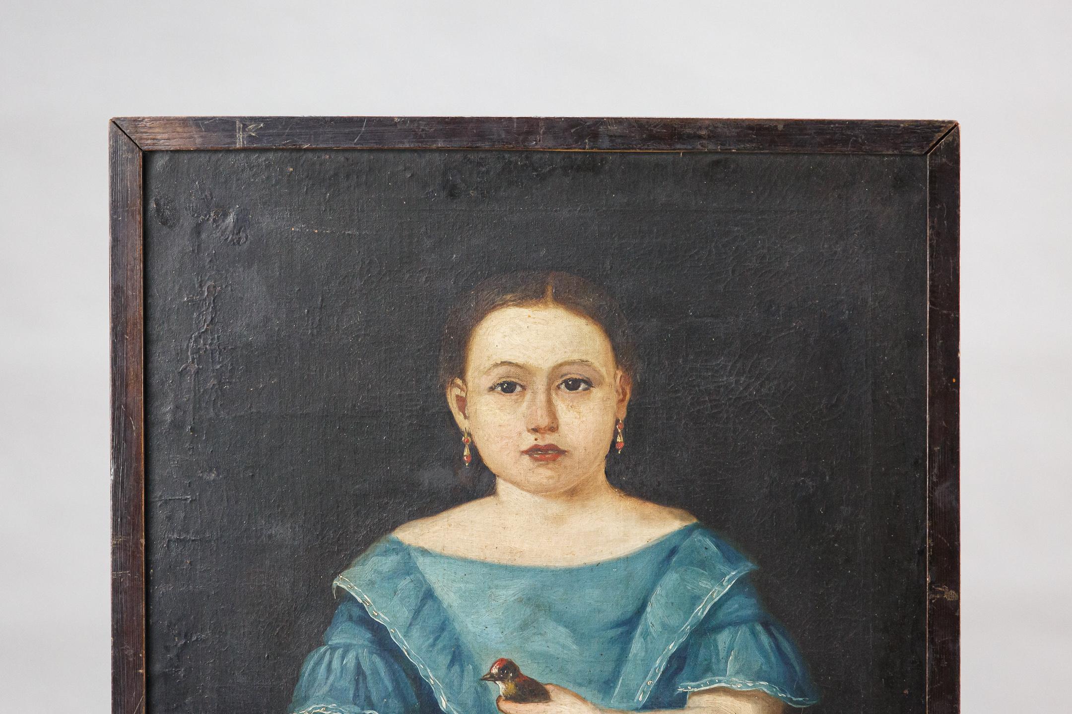 Engaging 19th century oil on canvas naive school portrait of a girl in a blue dress holding a bird. France Circa 1860.