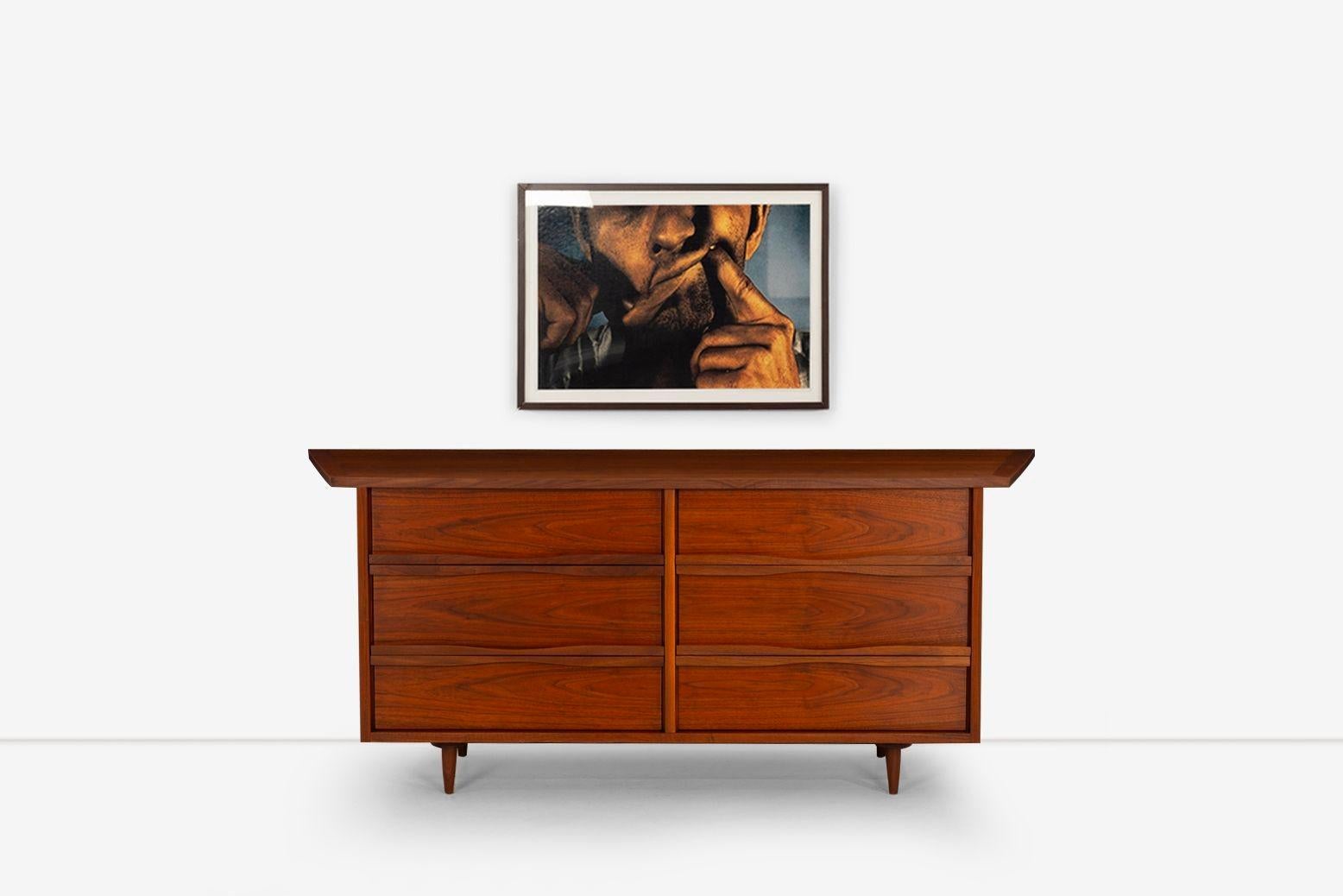 Nakashima Dresser for Widdicomb Orgins Line in walnut wood with oil finish, The angeled One inch-thick top overhangs a six-drawer case with carved horizontal handles. Solid-turned walnut legs
Incised 