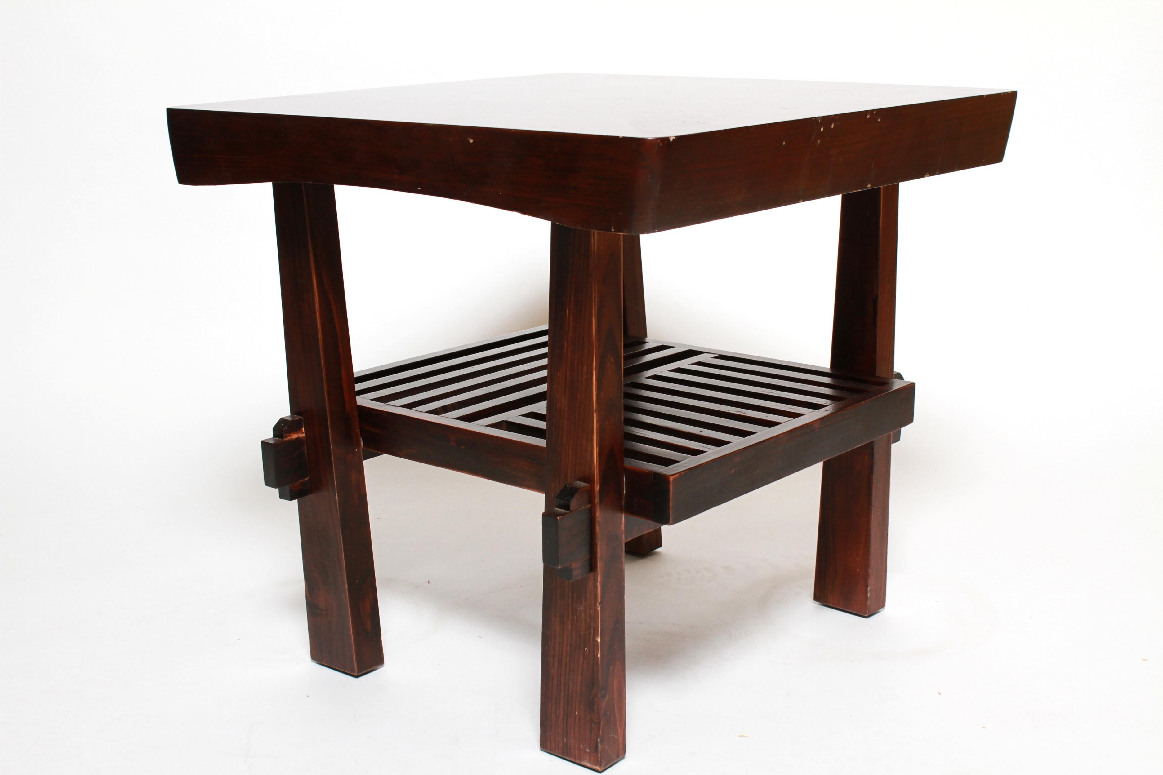 Asian style side table with tenon construction and a single tier, designed in the style of Nakashima. The piece was made in the mid-late 20th century and is in good vintage condition with some age-related wear to the surfaces.