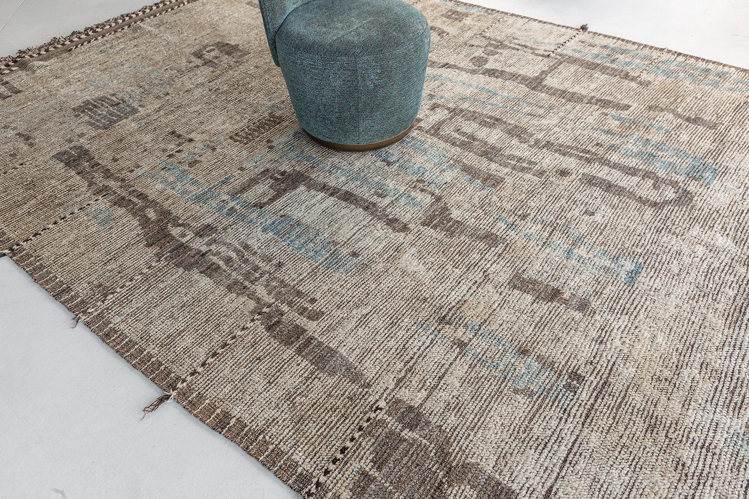 'Nakhla' is a natural earth toned rug and a modern interpretation of the Moroccan world. This rugs irregular ivory, khaki, blue, and salt and pepper strokes resembles the fibers of nature and their ability to be used for crafts such as cords and