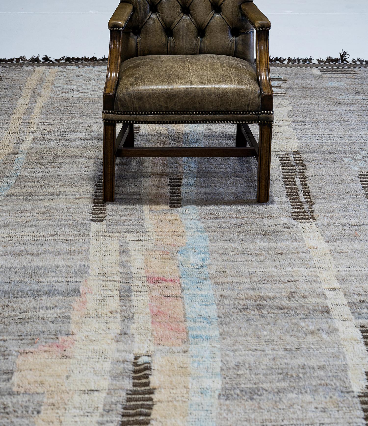 Nakhla' is a natural earth toned rug and a modern interpretation of the Moroccan world. This rugs irregular natural grey, blue, pinkish-orange, yellow, and salt and pepper strokes resembles the fibers of nature and their ability to be used for