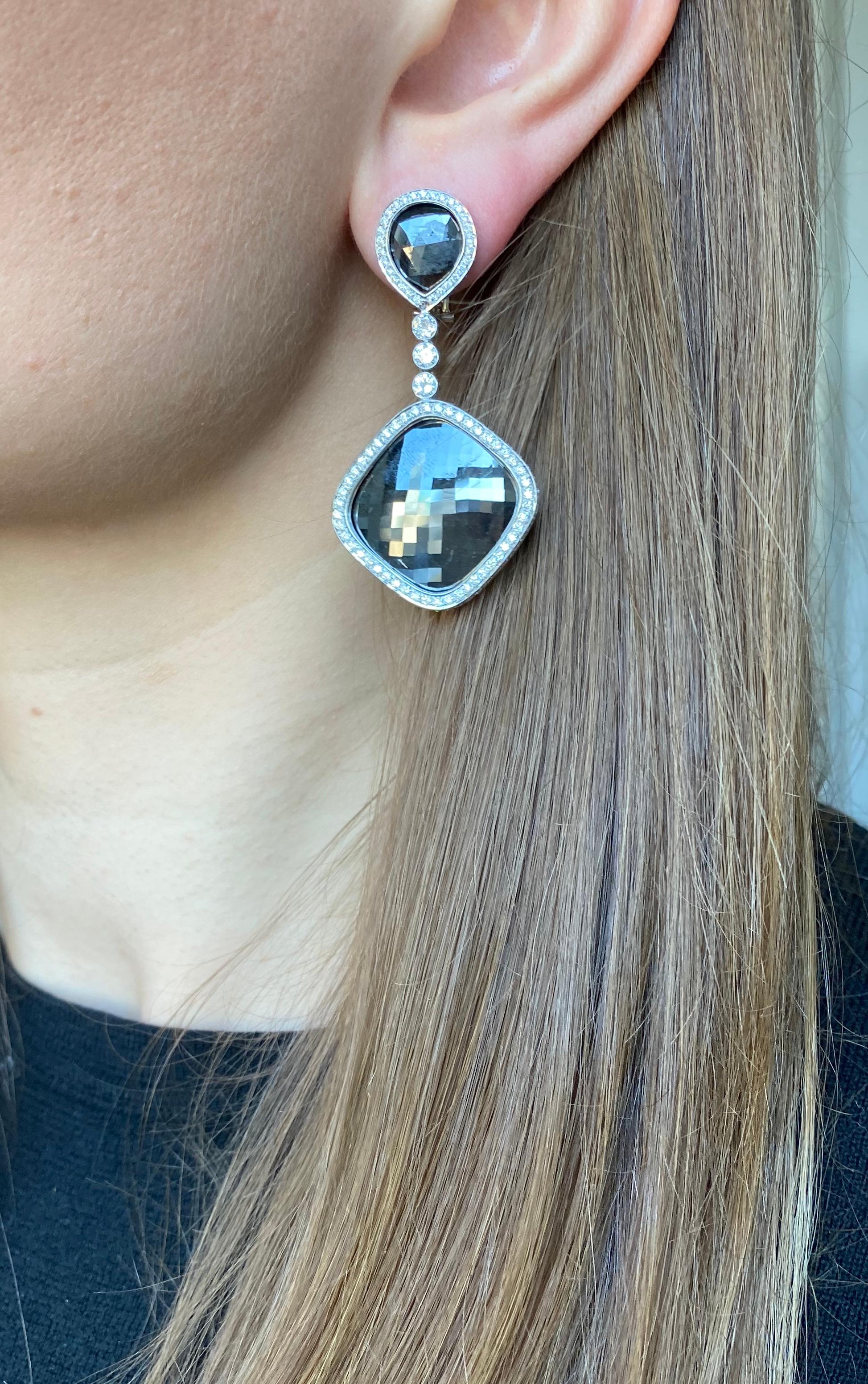 One of a kind! Black rose cut diamond earrings surrounded with white diamonds.
Top is 2 pear shape black rose cut diamonds(7.25 carats)
surrounded with white diamonds, hanging 3 bezel style set diamonds connected to a larger rose cut black diamonds