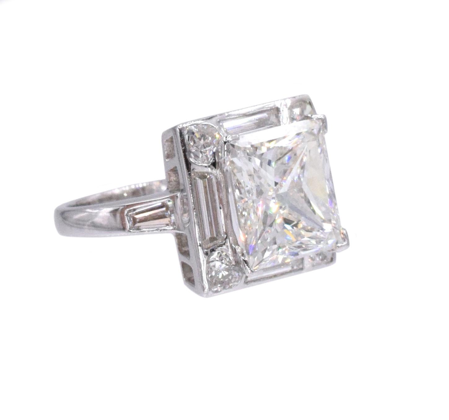 Diamond engagement ring in platinum.
Center of the ring set with 4.01ct princess cut diamond, color G, clarity VS1, GIA#8440332. Placed in a platinum mounting set with four trapezoid cut diamonds weighing total of 0.73ct, four heart shaped diamonds