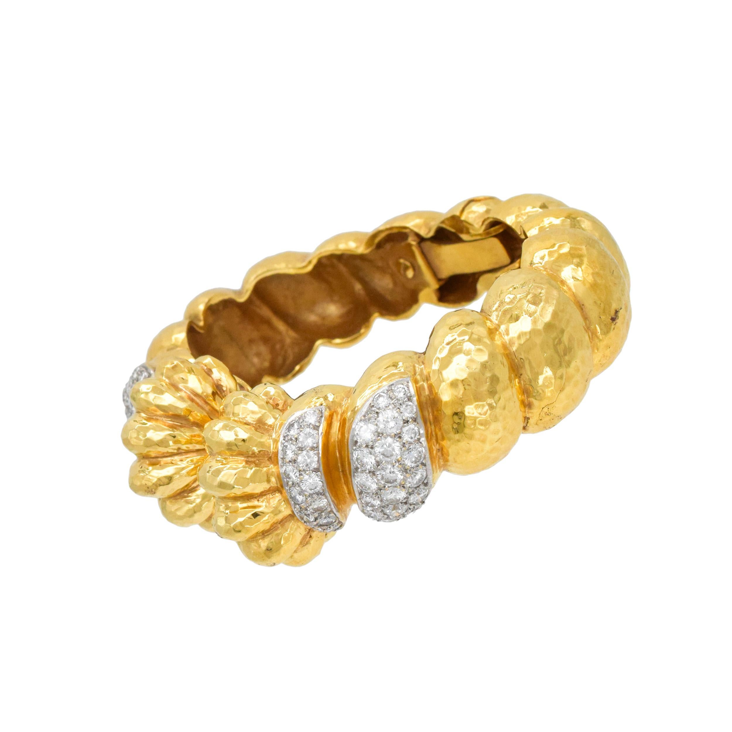 Bracelet manchette en or jaune 18k martel�é et diamant en or jaune 18k. Le bracelet présente un design cannelé gradué avec des
finition martelée. Quatre maillons avant incrustés de diamants ronds de taille brillant. Il y a 72 diamants ronds de taille