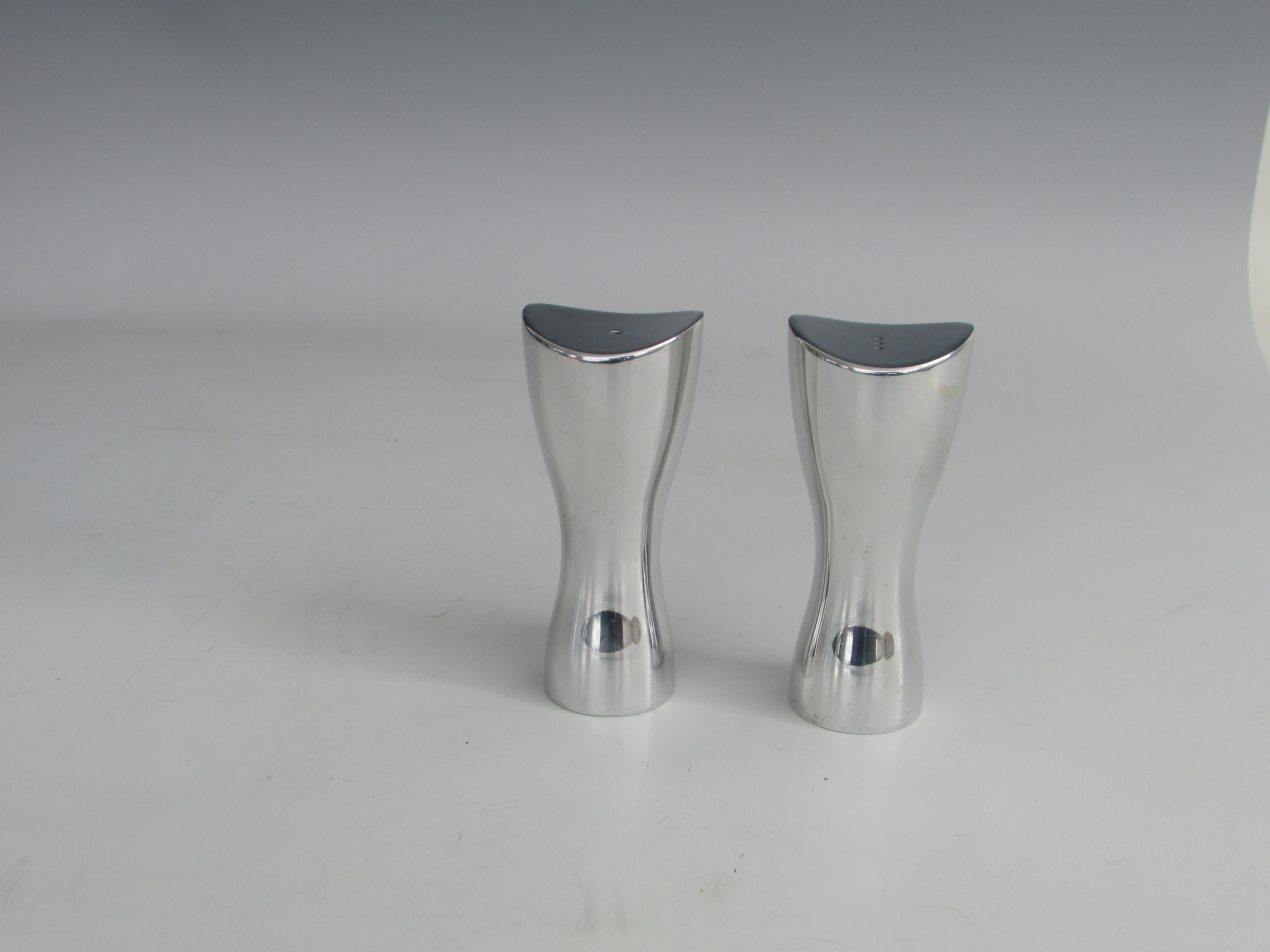 Pair of polished aluminum stylized hour glass form salt pepper shakers. Marked with Nambe Studio label.